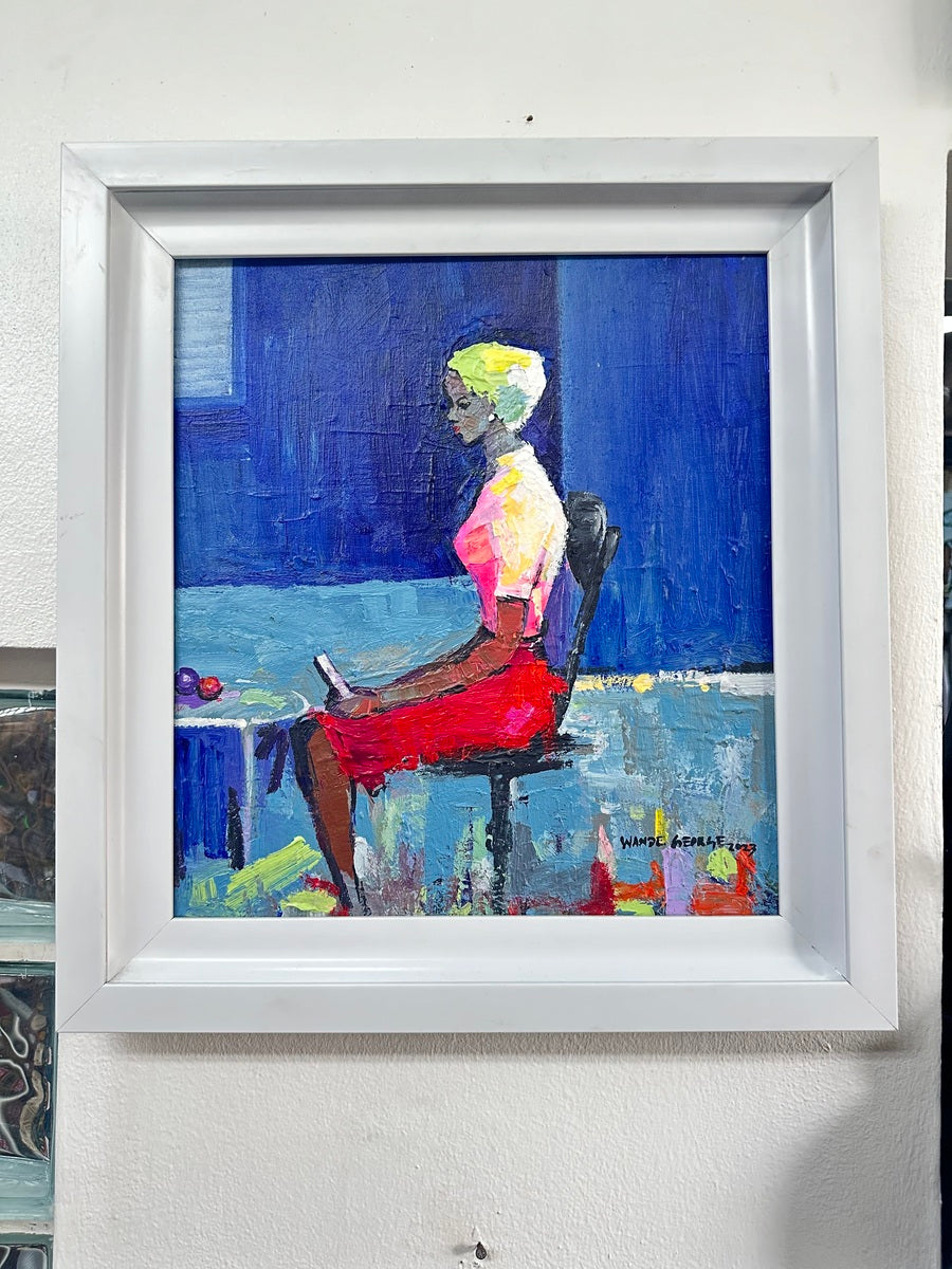 Graceful Pose" by Wande George is a framed acrylic on canvas painting of a woman with short blond hair in a pink top and red skirt, seated sideways on a chair against a blue background, hands resting on her lap.