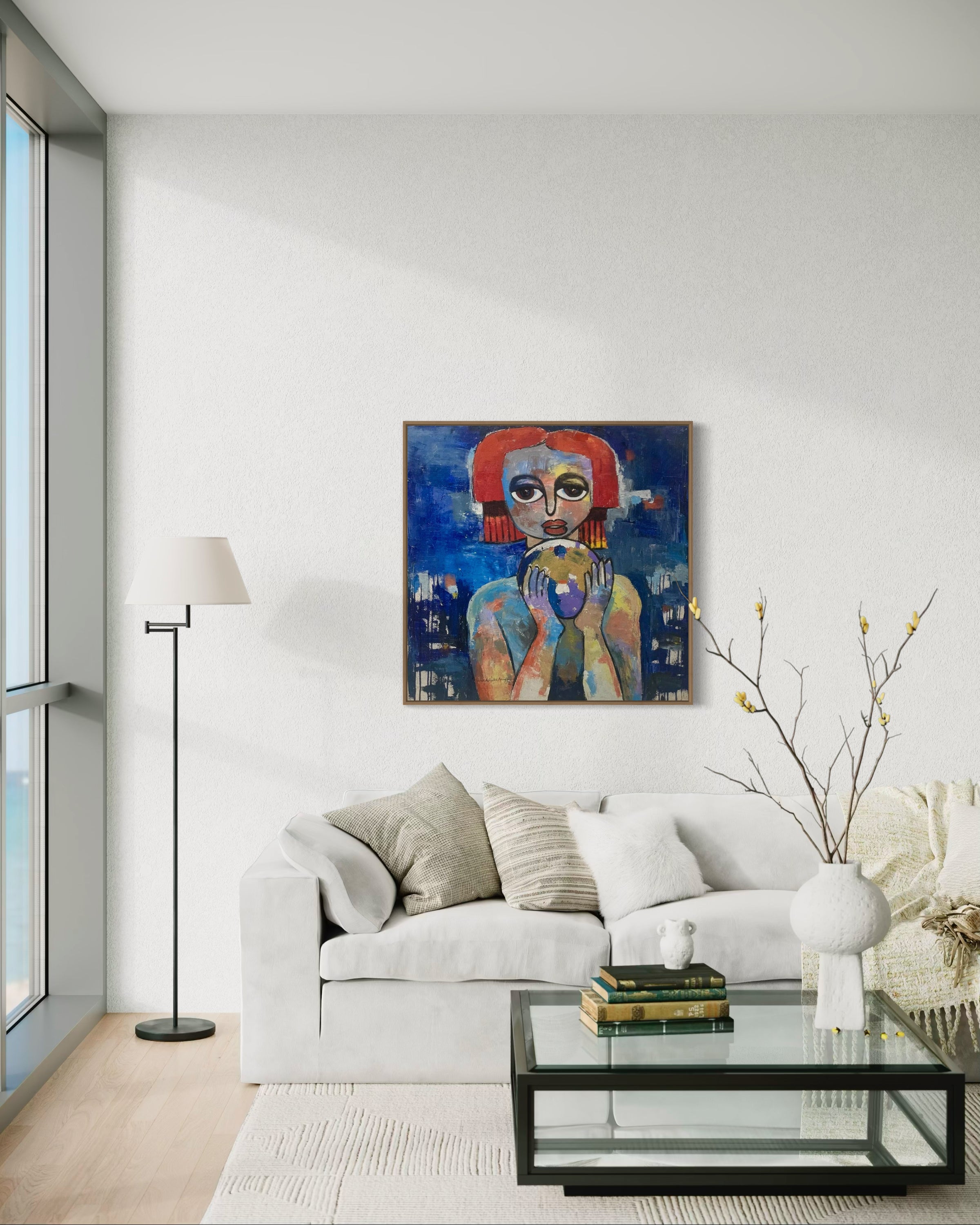 A modern living room with a white sofa, glass coffee table, and floor lamp. Above the sofa hangs 'My World, Destiny Is In My Hands' by Achike Anayo, an abstract portrait of a red-haired woman with certificate of authenticity. A vase is on the table.