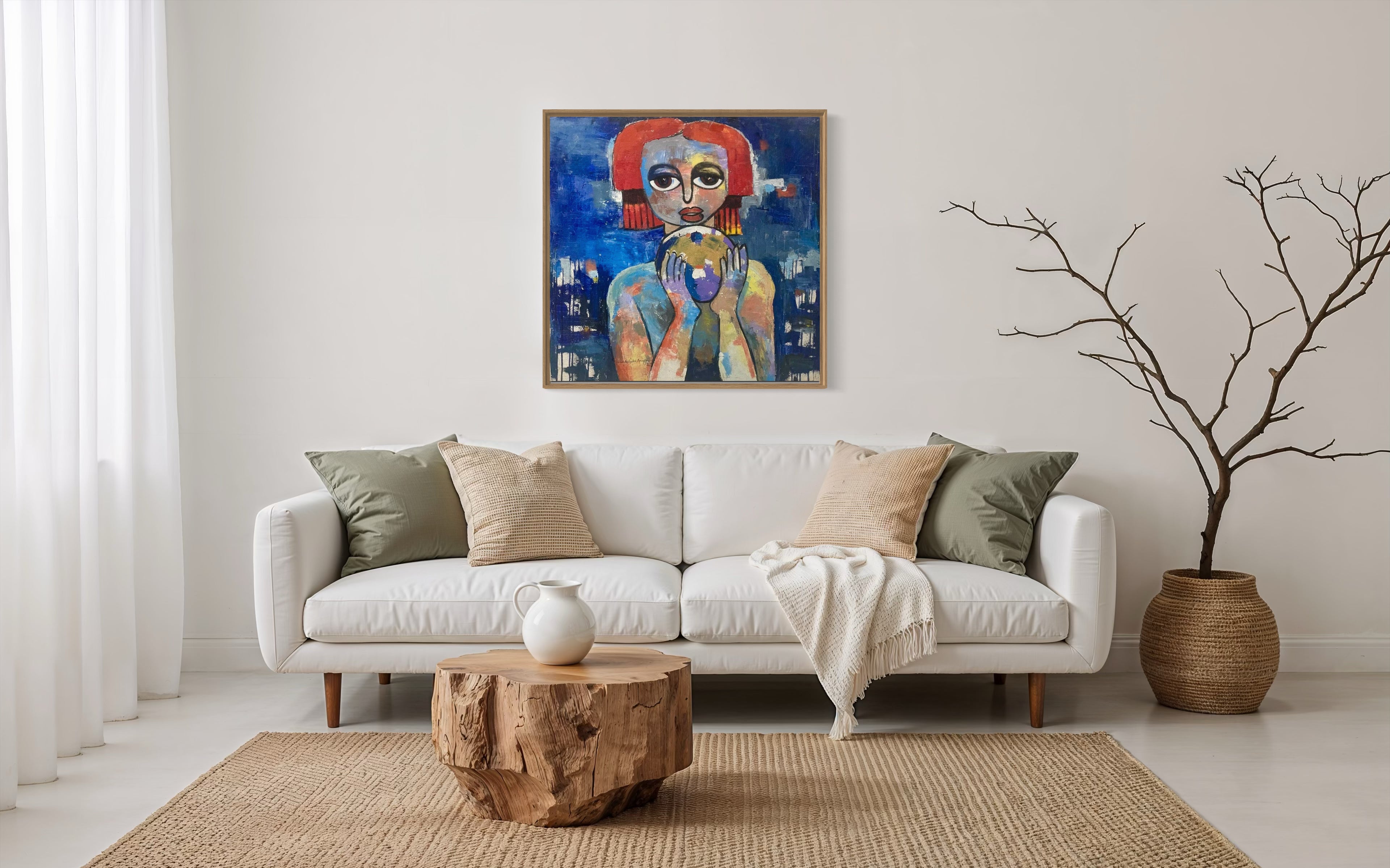 A modern living room with a white sofa, neutral pillows, a beige throw, wooden coffee table, woven rug, and a large vase of branches features 'My World, Destiny Is In My Hands' by Achike Anayo displayed above the sofa with certificate of authenticity.