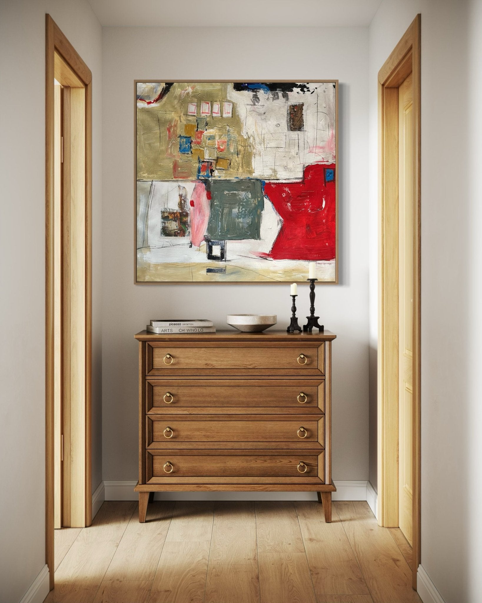 A narrow hallway with light wood flooring, a wooden chest of drawers, two black candlesticks, a bowl, and "Urban Tapestry" by Kehinde Badmuss—a contemporary abstract artwork—hanging above the dresser.