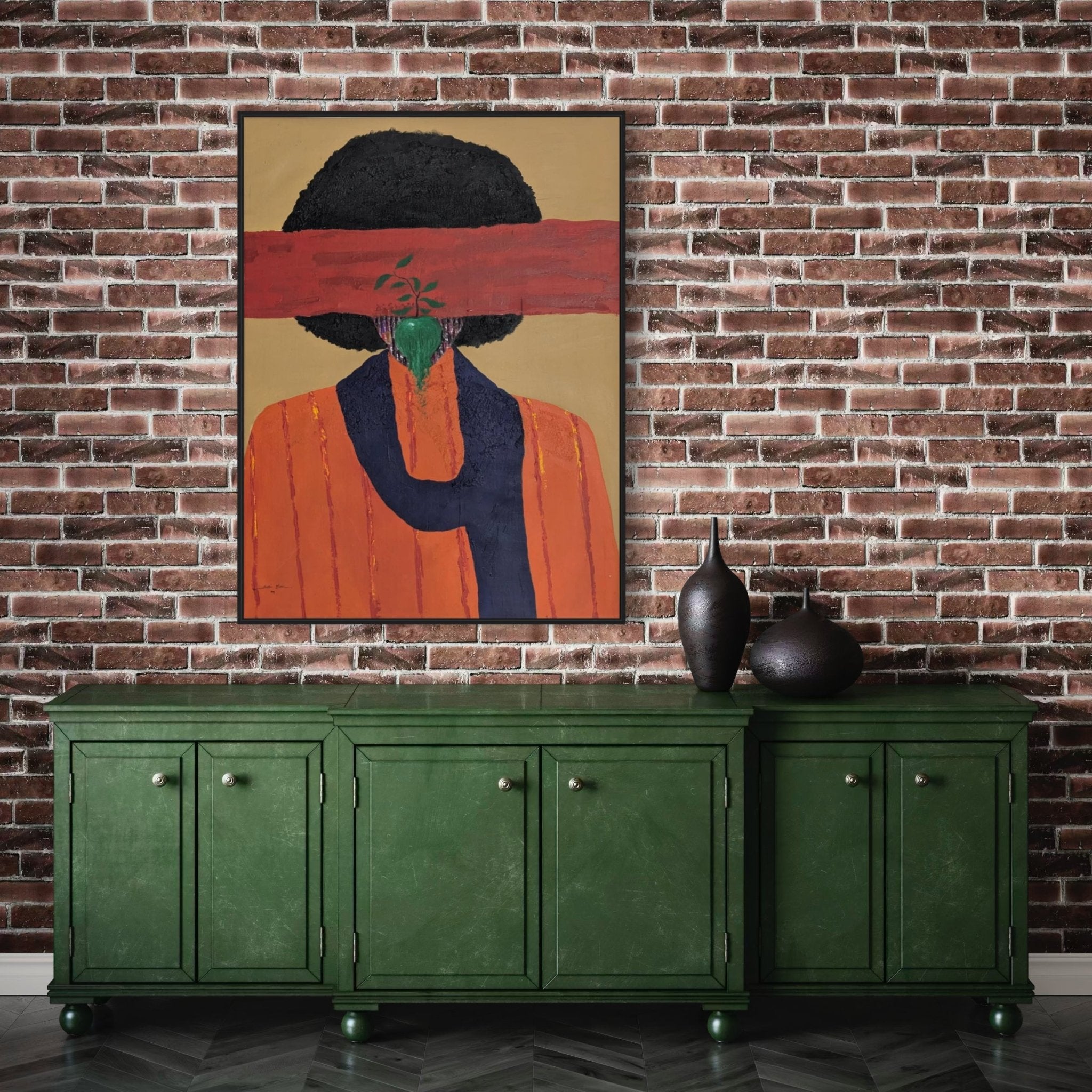 Slam Austin’s "Austin Slam – Growth II" (Mixed Media on Canvas), inspired by African contemporary art, hangs above a green cabinet on a brick wall; it features an abstract orange figure with a black afro, red stripe, and small green plant. Three black vases sit below.