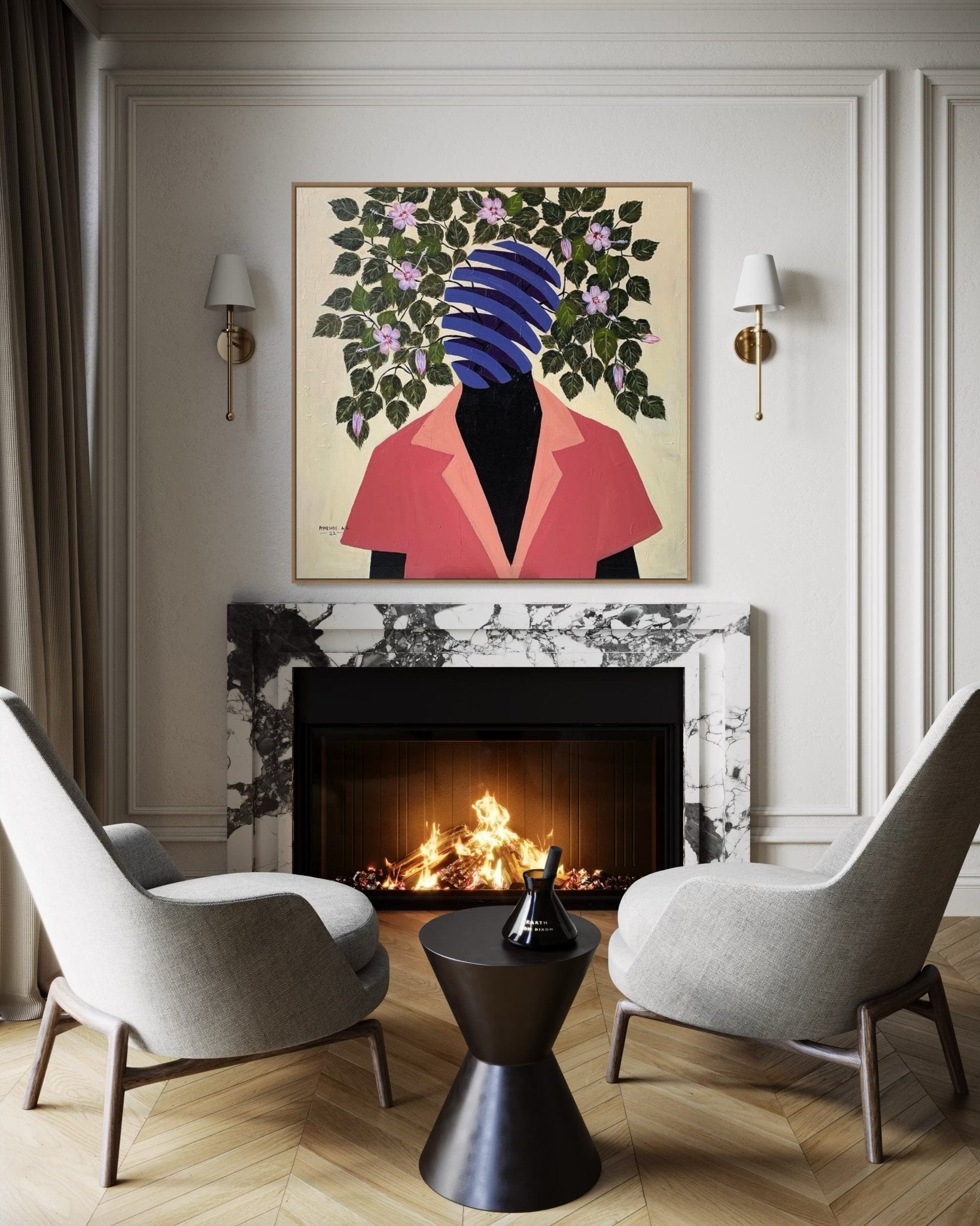 Two modern gray chairs face a marble fireplace with a fire. Above the mantel hangs "Beyond Me" by Ayorinde Ayobami Lekan—a painting of a figure in a red jacket with a blue-striped, plant-covered head. White paneled walls and gold sconces complete the room.