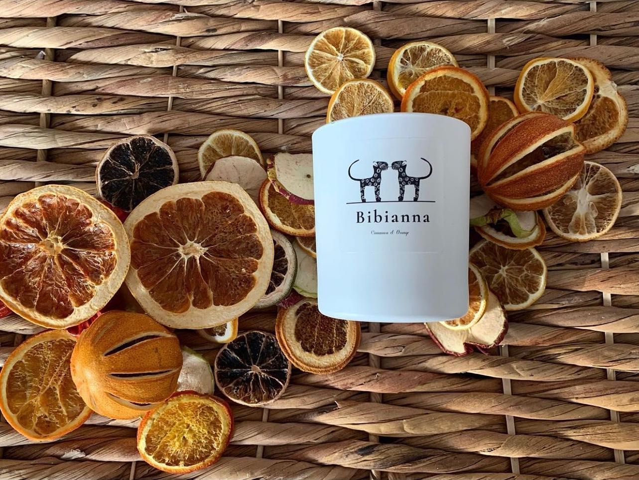 The Bibianna Luxury Scented Candle by bibianna.co.uk features cinnamon and orange fragrances, presented with dried citrus accents—an elegant, hand poured touch to elevate any space.