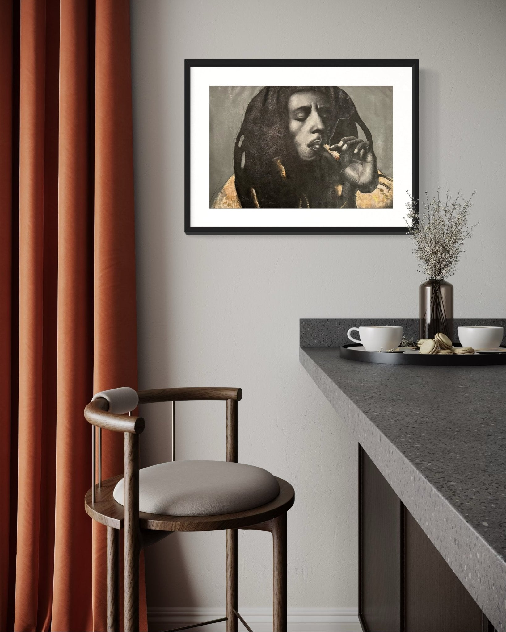 A modern kitchen featuring gray countertops, a wooden bar stool, orange curtains, and the Bob Marley Mixed Media Monochrome Painting by Kehinde Badmuss hanging above the counter.