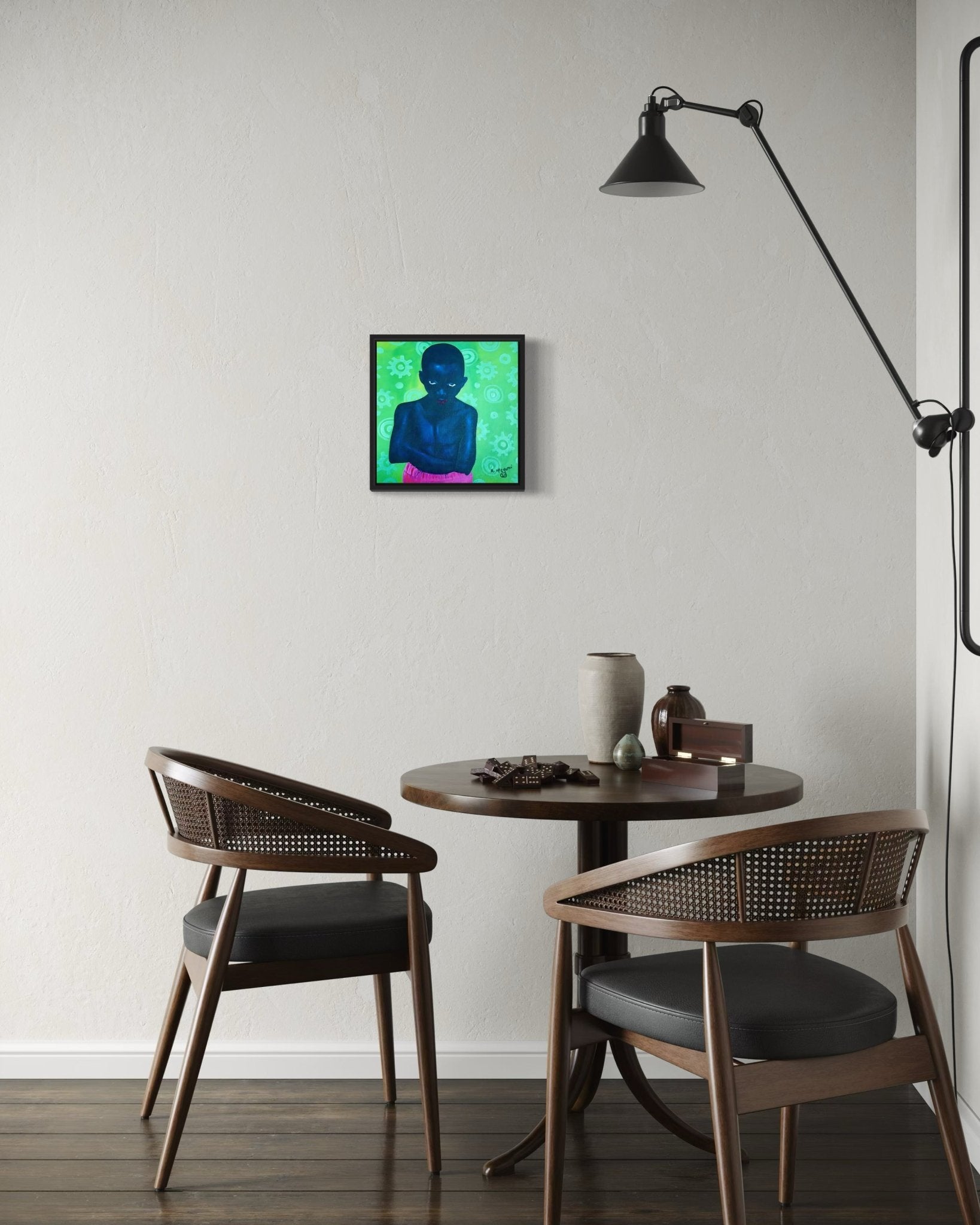A small round table with two chairs sits against a plain wall. Above it hangs "Boy In Pink Shorts" by Afuope Opeyemi, a colorful acrylic on canvas portrait with certificate of authenticity. A black wall lamp extends over pottery and decor.