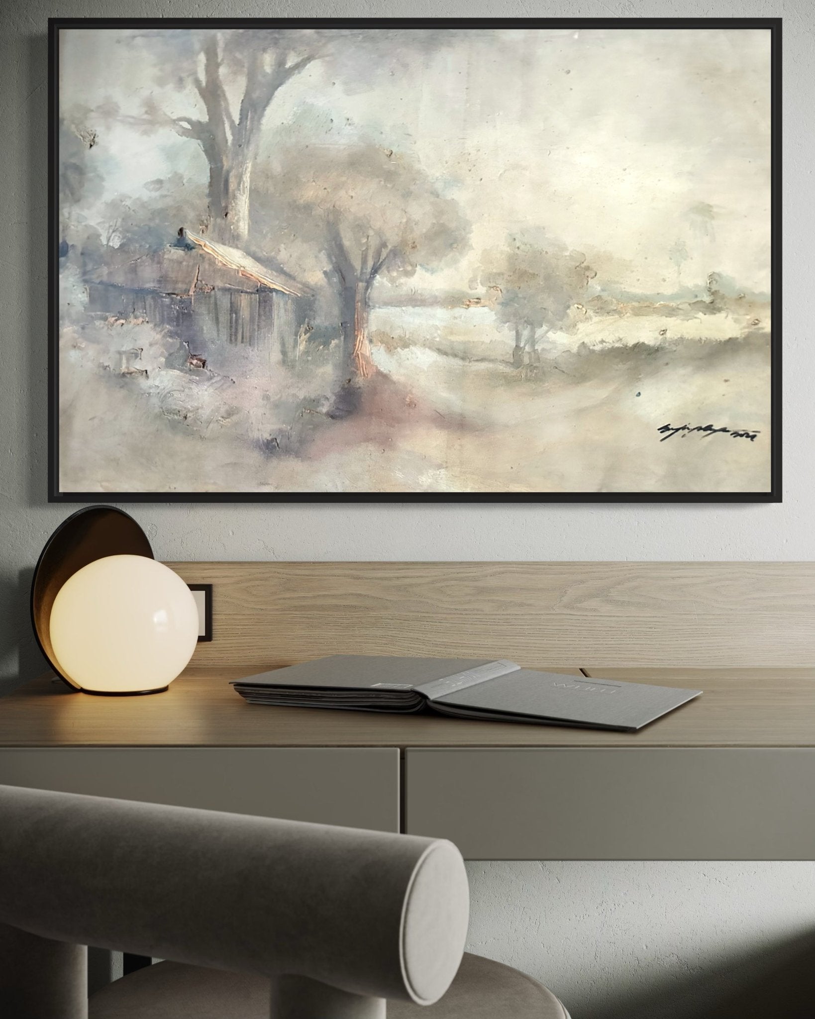 The "Elegant Pastel Classic Landscape Painting" by Doyin Bayo, hand-signed and framed, hangs above a minimal desk with an open notebook and round lamp, adding calm artistry to your workspace. Includes certificate of authenticity.
