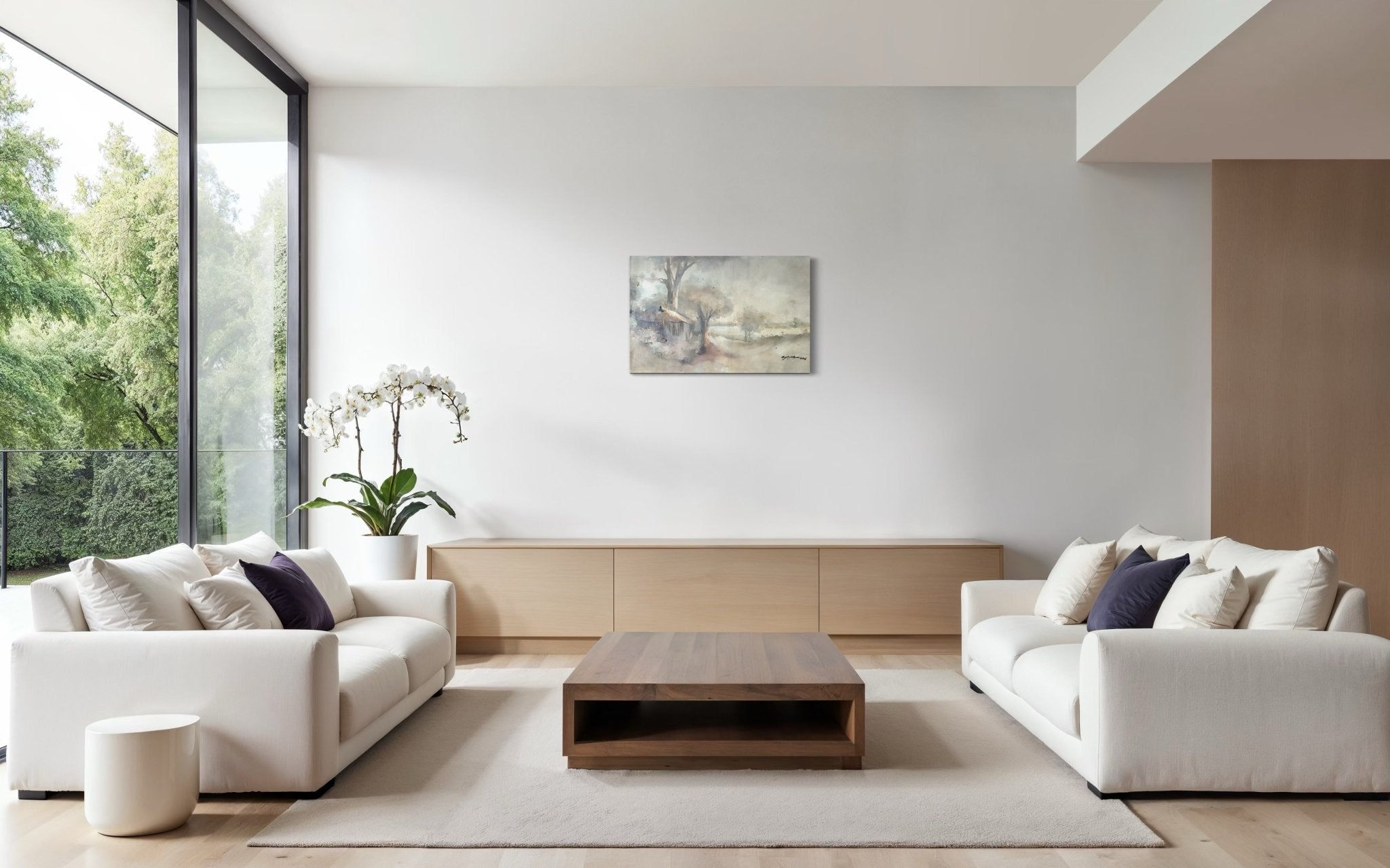 A modern living room with two white sofas, a wooden coffee table, light rug, large window with greenery views, orchid plant, and a hand-signed "Elegant Pastel Classic Landscape Painting" by Doyin Bayo on a white wall.