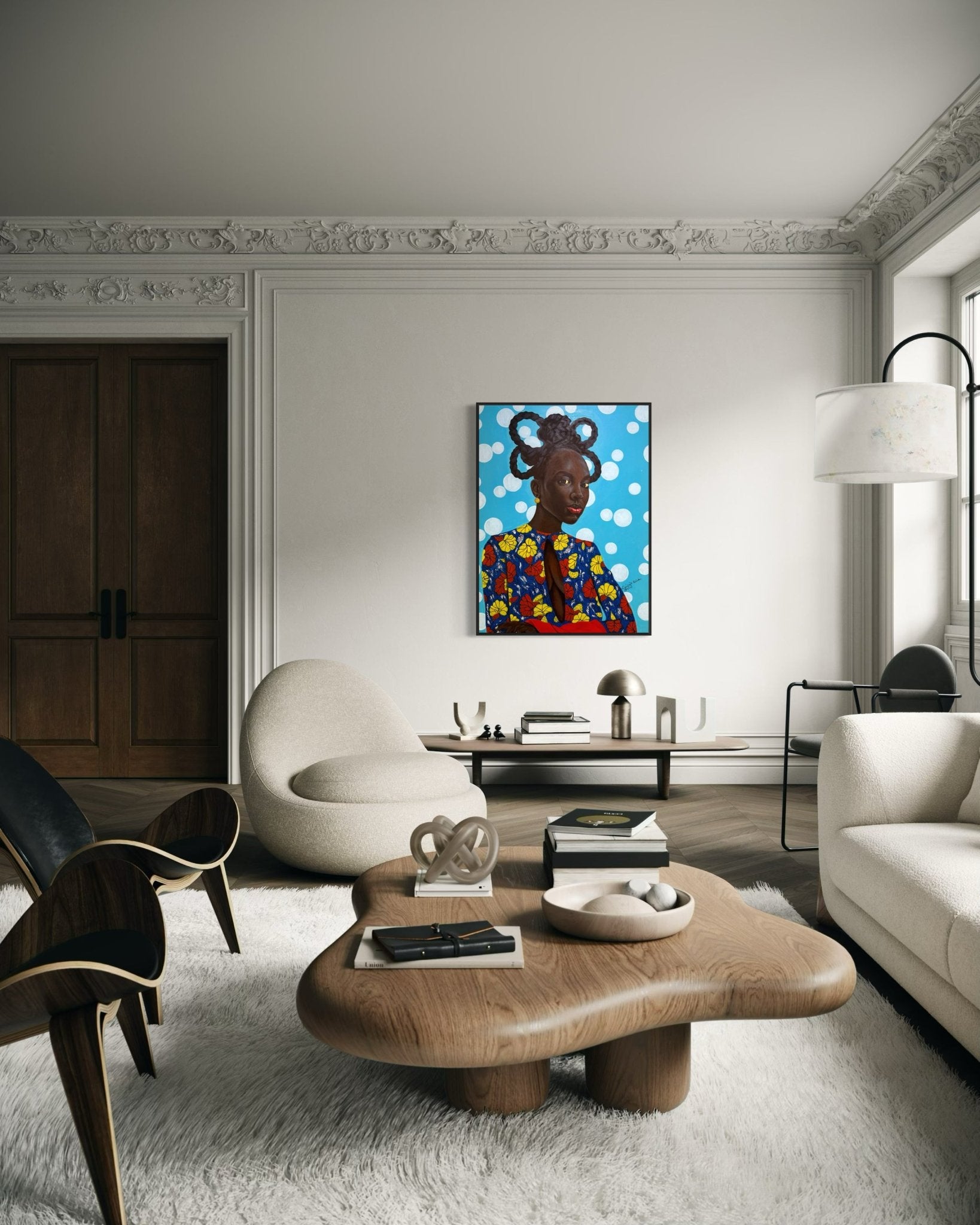A modern living room with stylish furniture, a sculptural wooden coffee table, white rug, and "Enigmatic Beauty: 'Lady'" by Ajenifuja Abiodun—a vibrant contemporary African art portrait—adds an eye-catching touch to the wall.