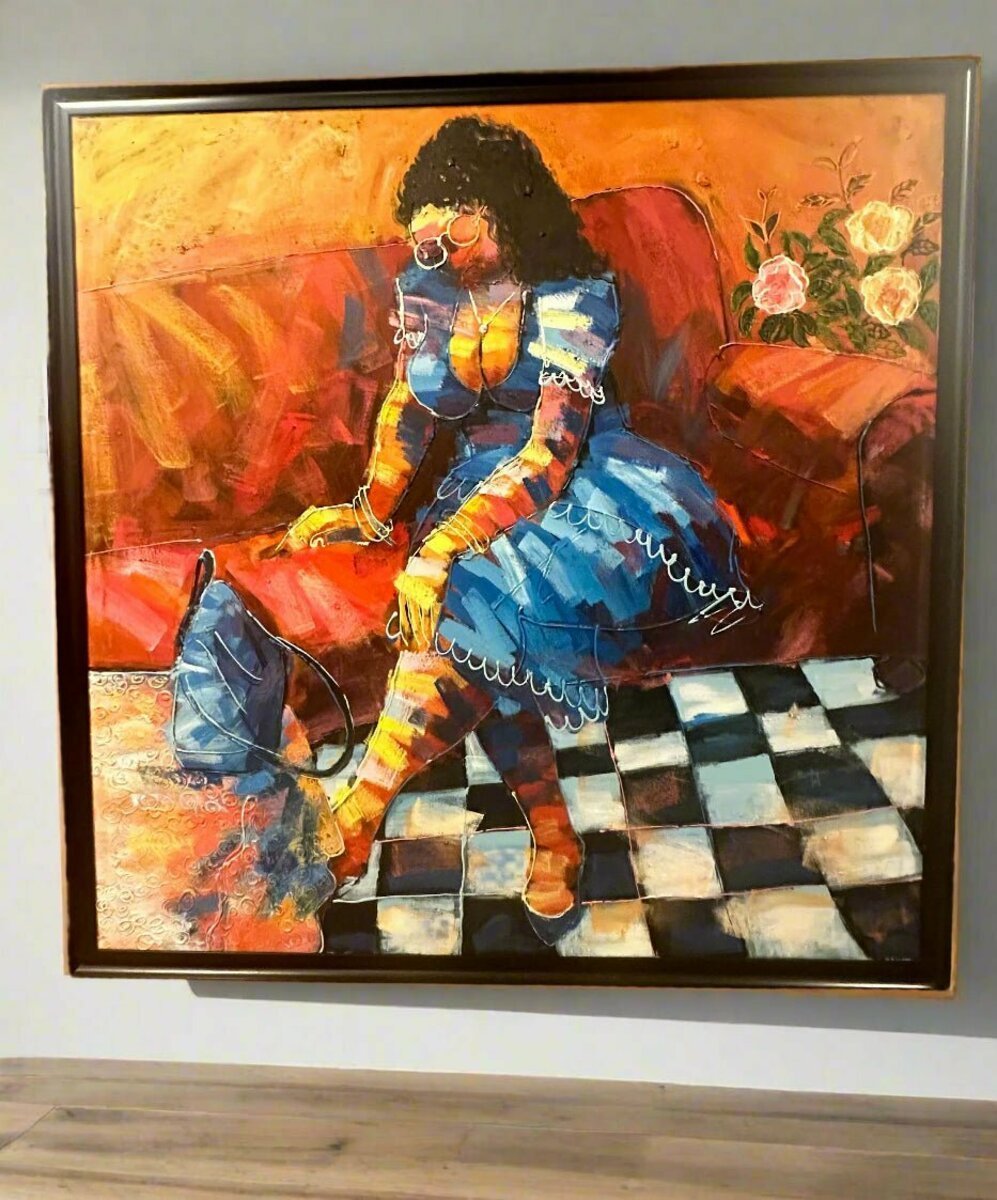 “Expectation” by Yomi Sokenu is an expressive acrylic on canvas showing a woman in a blue dress on a red couch, adjusting her shoe, with checkerboard flooring, a nearby bag, and blooming flowers in the background.