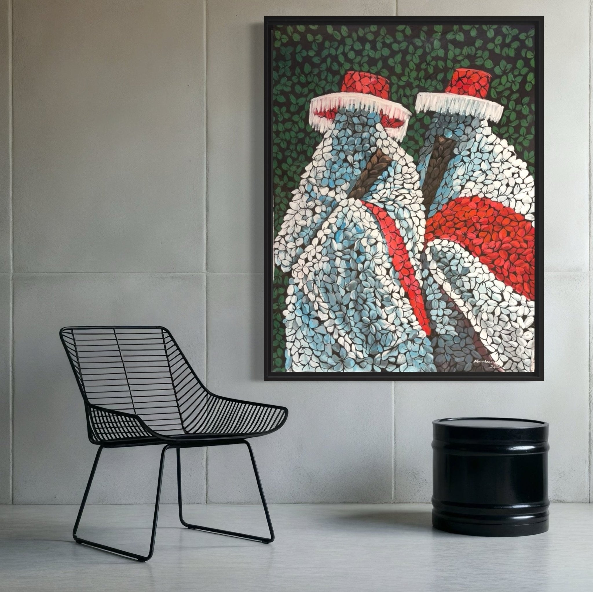 A modern room with a wireframe chair and black cylindrical side table features "Eyo Festival," a colorful acrylic on canvas painting by Abubakar Nurudeen, depicting two abstract cloaked figures with red hats against a leafy green background.
