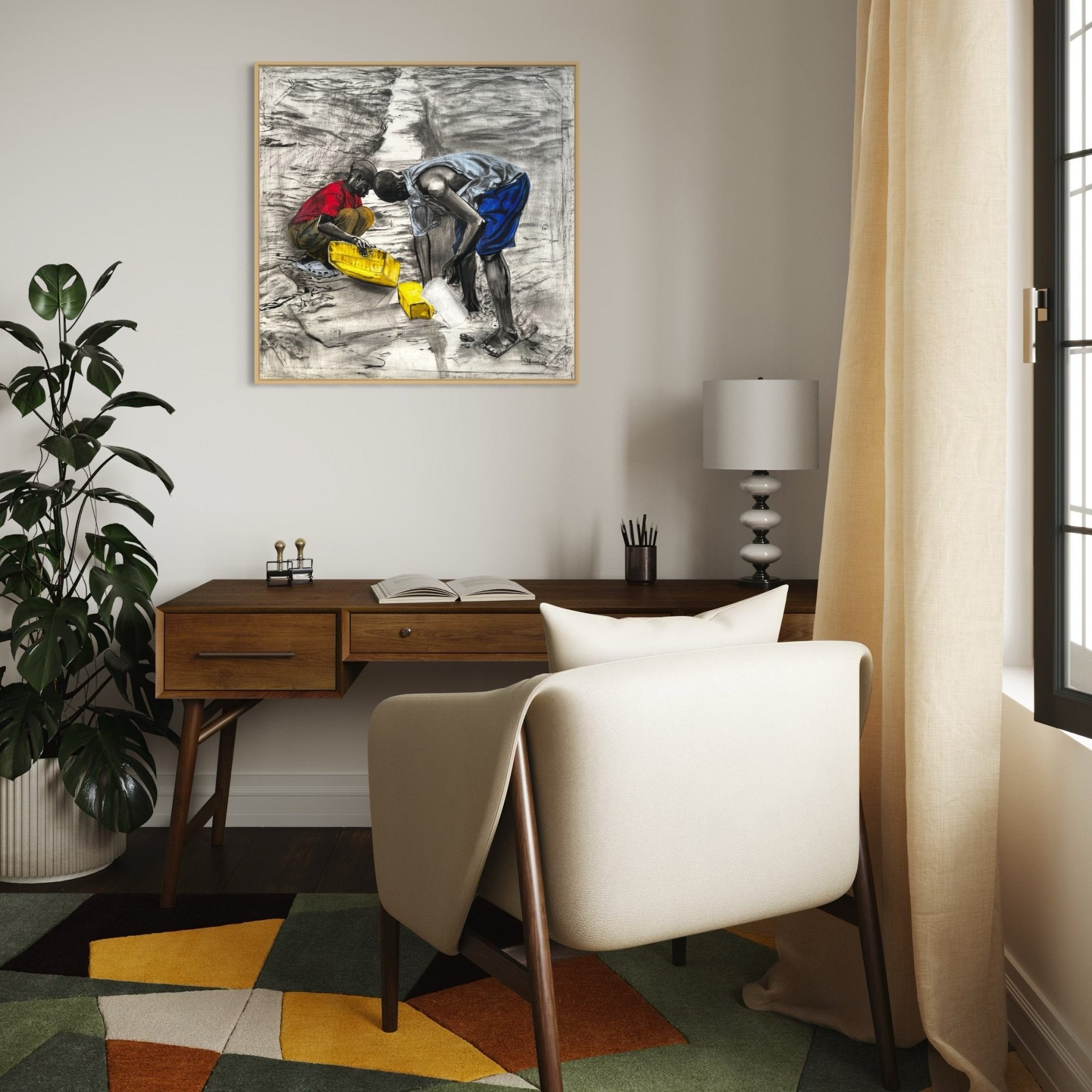 A modern home office features a wooden desk, white chair, lamp, plant, and colorful geometric rug. Above the desk hangs "Fetching Water" by Bibianna African Art Collective, depicting two people with yellow and blue containers and clothing.