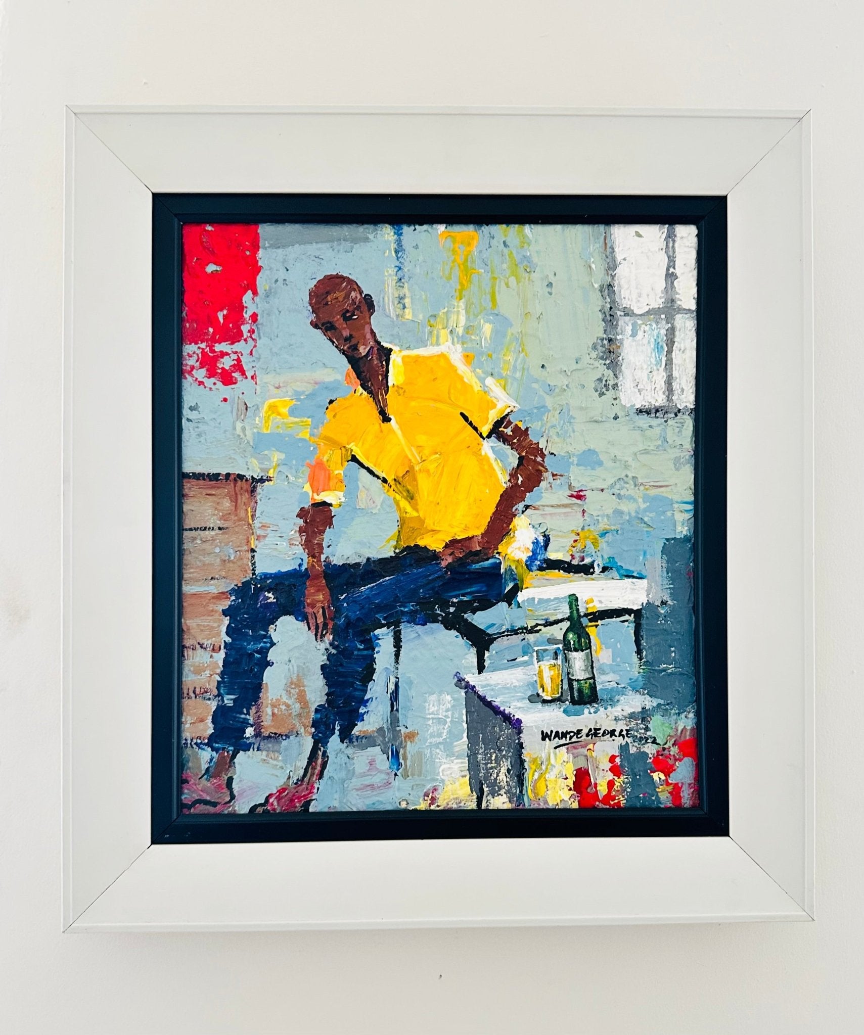Good Company" by Nigerian contemporary artist Wande George is a colorful acrylic on canvas showing a man in yellow and blue seated on a ledge with bottle and glass, set against an abstract background. This hand-signed piece comes framed in white.