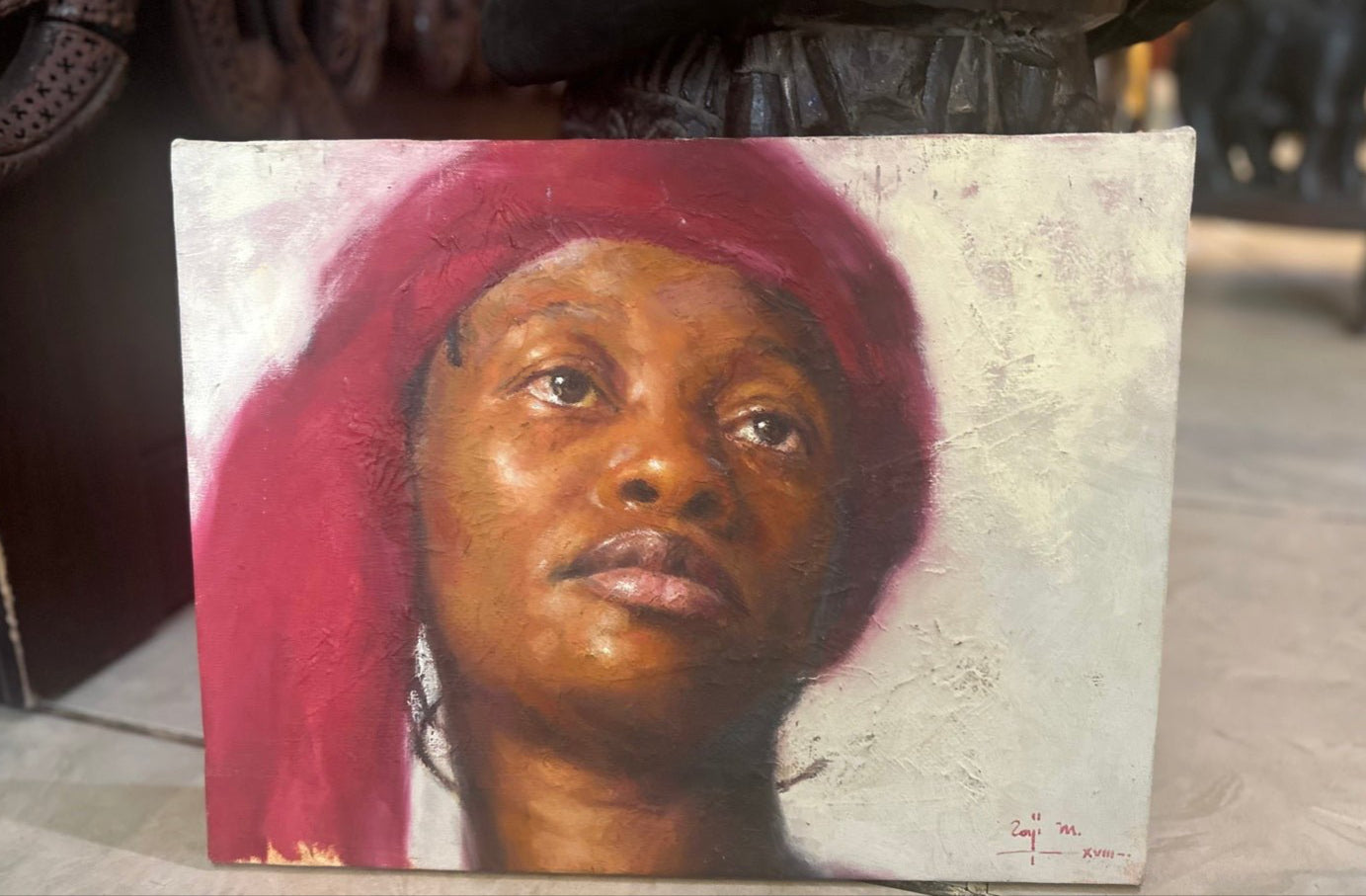 Looking Ahead" from the Expectation Series by renowned Nigerian portrait artist Raji Mohammed is a realistic oil on canvas of a woman with a red headscarf, gazing upward against a light textured background, her face softly lit and expressive.