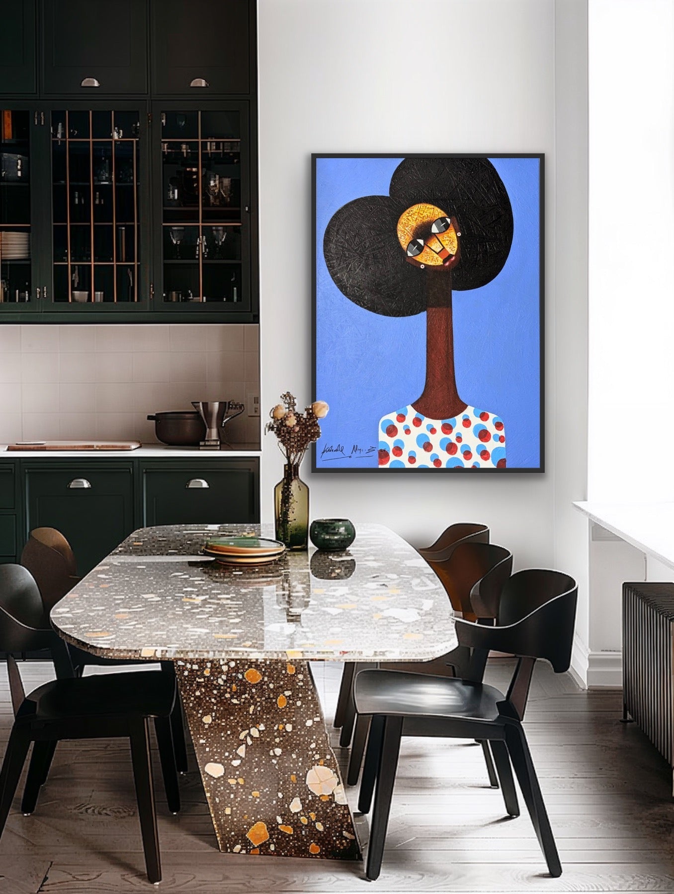 A modern dining room with a terrazzo table, four black chairs, dark green cabinets, and Kolawale Niyi's Charming Cubist Portrait With Textured Details—a colorful acrylic on canvas—hanging on a white wall.