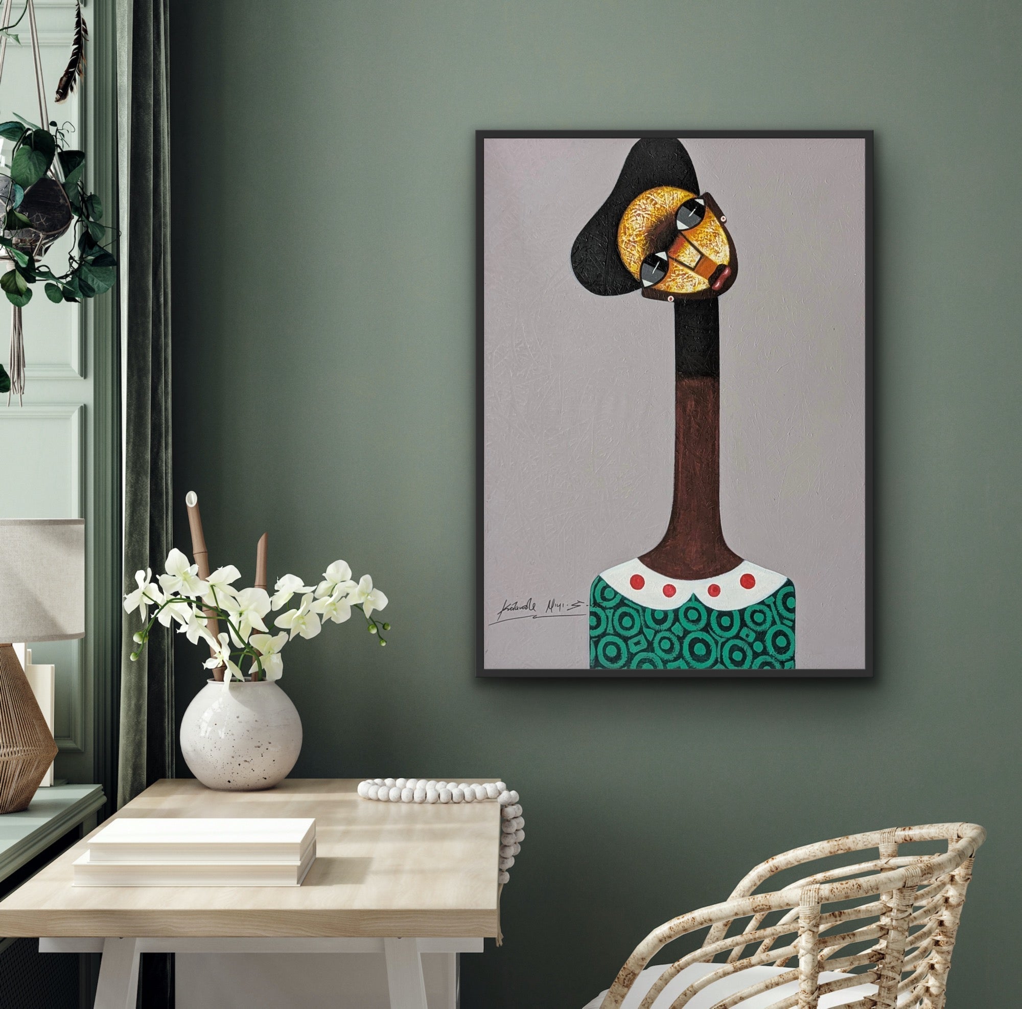 The Kolawale Niyi Cubist Portrait, a hand-signed acrylic on canvas by Kolawale Niyi, is framed and displayed above a desk with white flowers in a modern room with green and neutral decor.