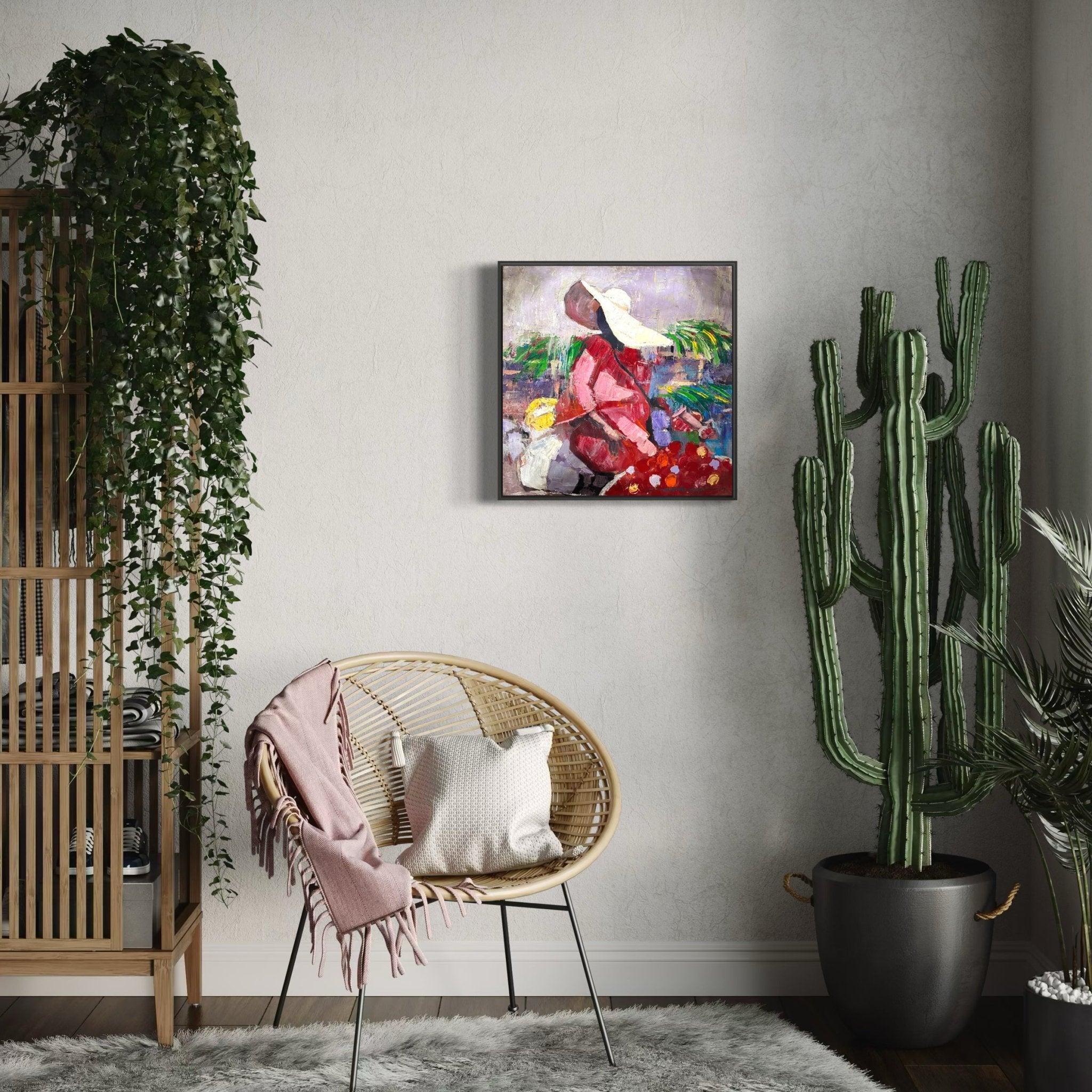 A cozy room features a rattan chair with a pink throw and white pillow, potted cactus, hanging plant, bamboo shelving, and the "Market Sance" Lady In Sun Hat original by NOSA OSADOLOR on the light gray wall.