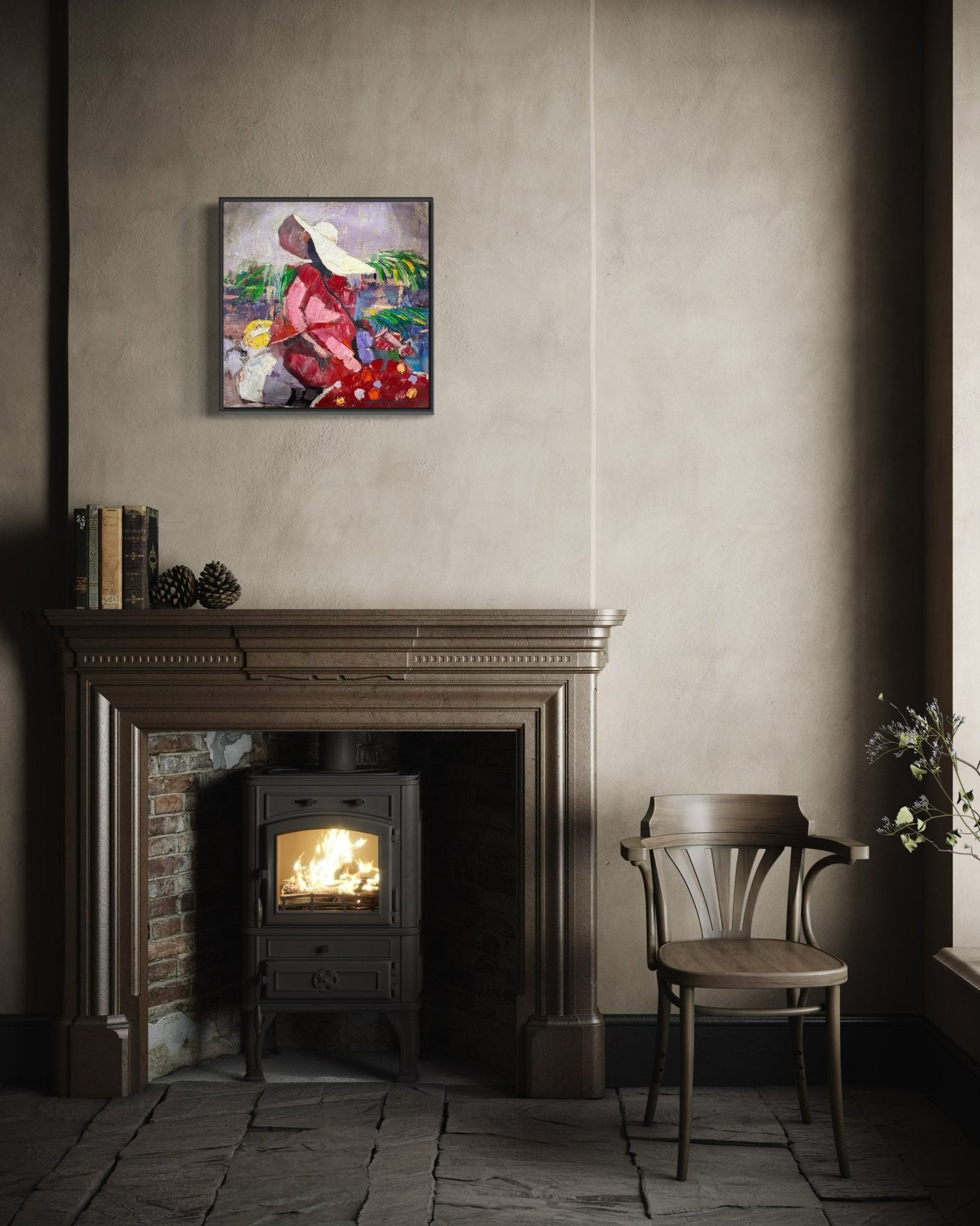 A cozy room features a wooden chair, a lit wood stove in a brick fireplace, books and pinecones on the mantel, and "Market Sance" Lady in Sun Hat by NOSA OSADOLOR—an original acrylic on canvas—hanging above.