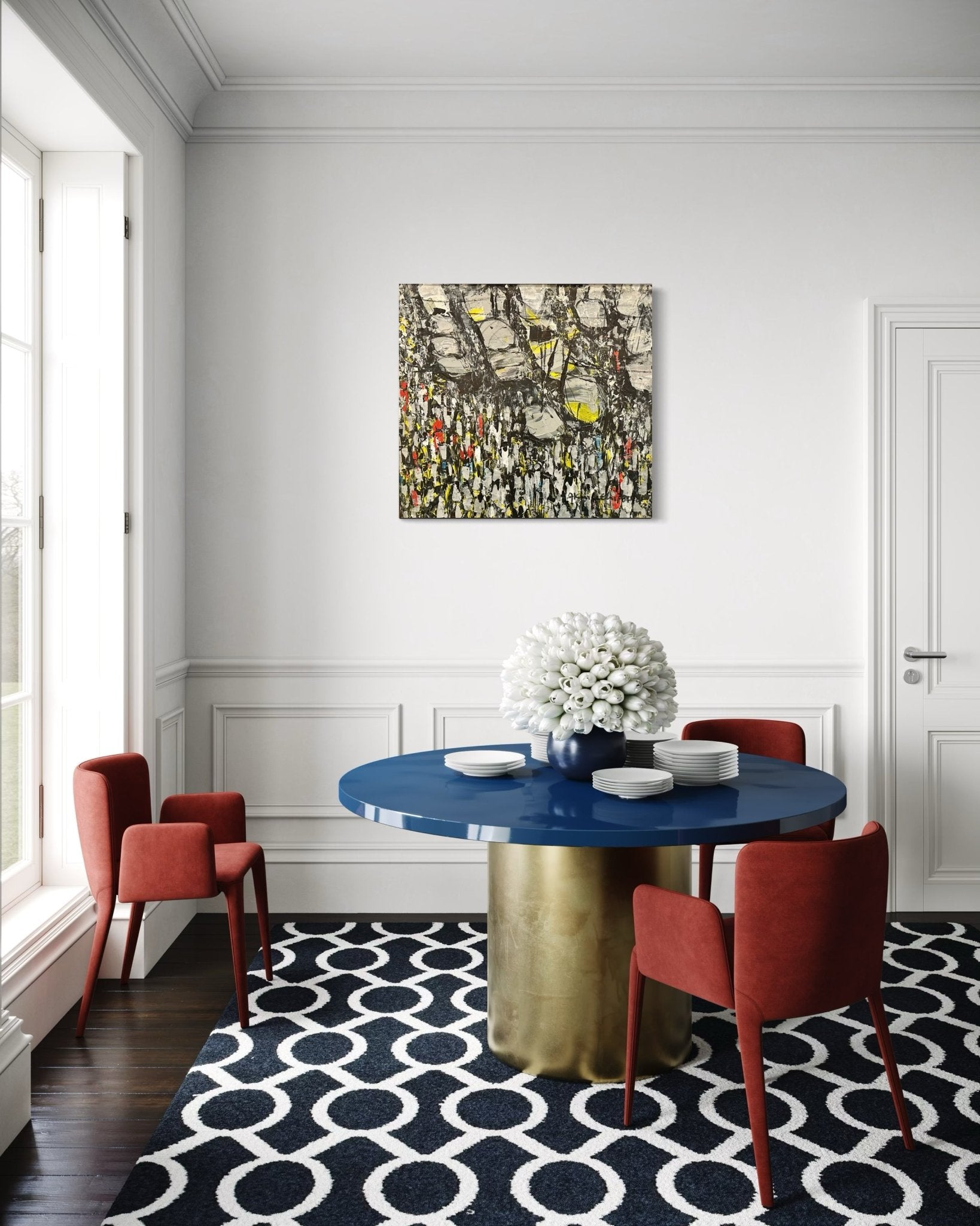 A modern dining room features a round blue table, four red chairs, a black-and-white geometric rug, and a vase of white flowers. "Making Our Way Home" by Akhile Ehiforia—a hand-signed painting of a Nigerian street market—hangs on the wall.