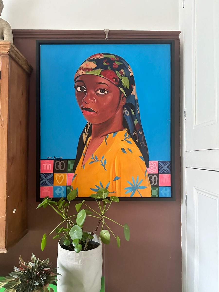 Marthas Flowers" Portrait by Azeez (Alabi Azeez) features a vibrant acrylic of a Black lady in a yellow patterned shirt and floral headscarf, set against a blue background with decorative blocks, displayed above a potted plant.