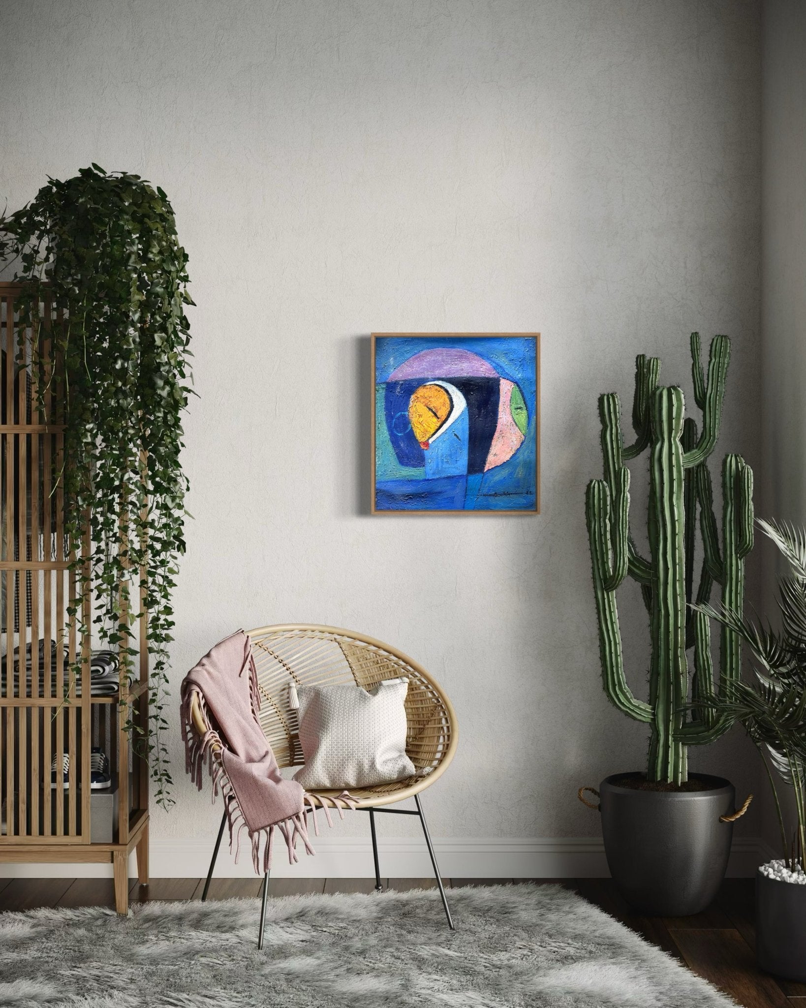 A cozy corner featuring a rattan chair with a pink blanket, white pillow, tall potted cactus, wooden plant stand with hanging greenery, and the NOSA OSADOLOR Miniature Textured Abstract—acrylic on canvas in an oak tray frame.