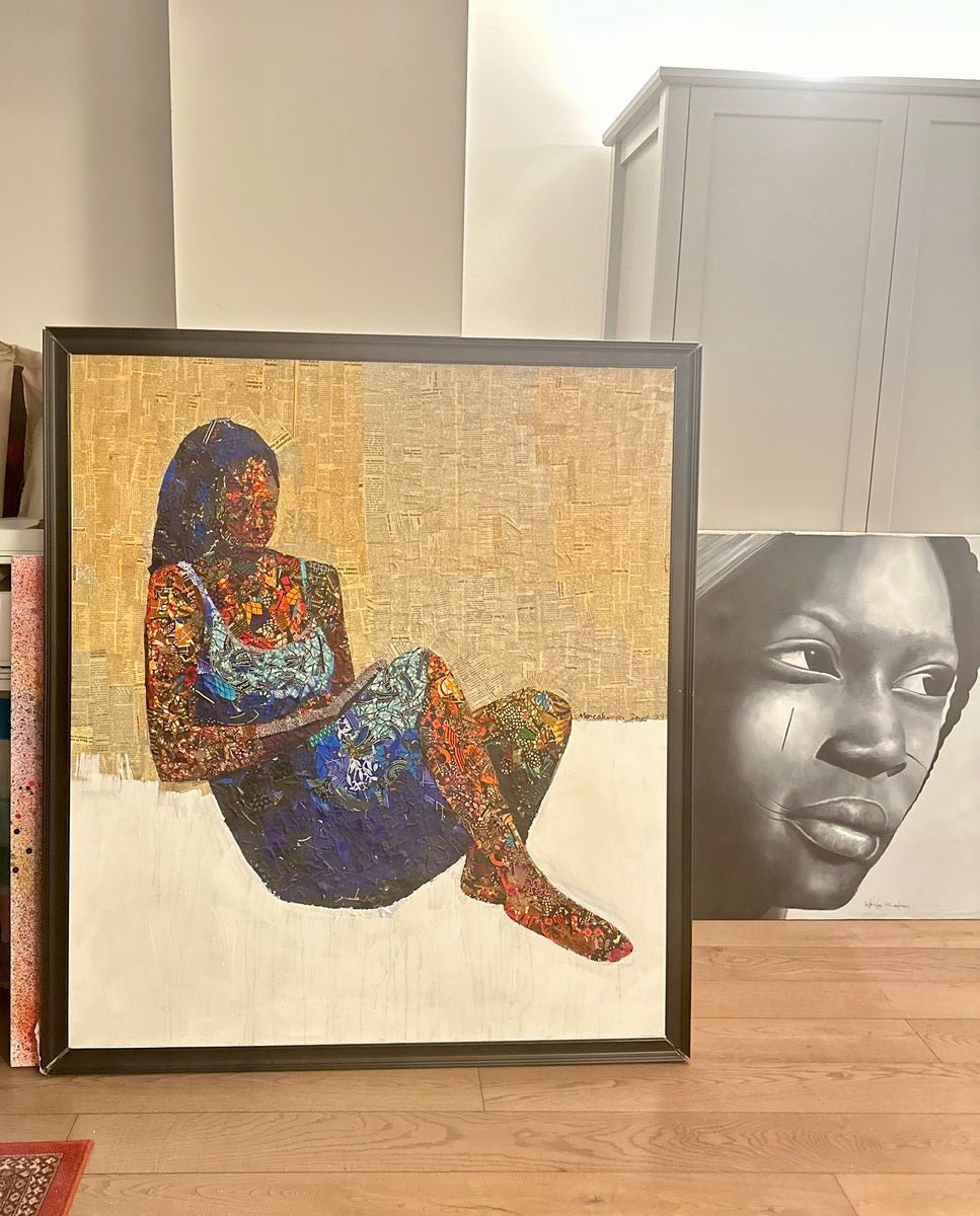 "Love Book," a mixed media painting of a woman in pages of writing, leans against the wall beside a black and white realistic portrait