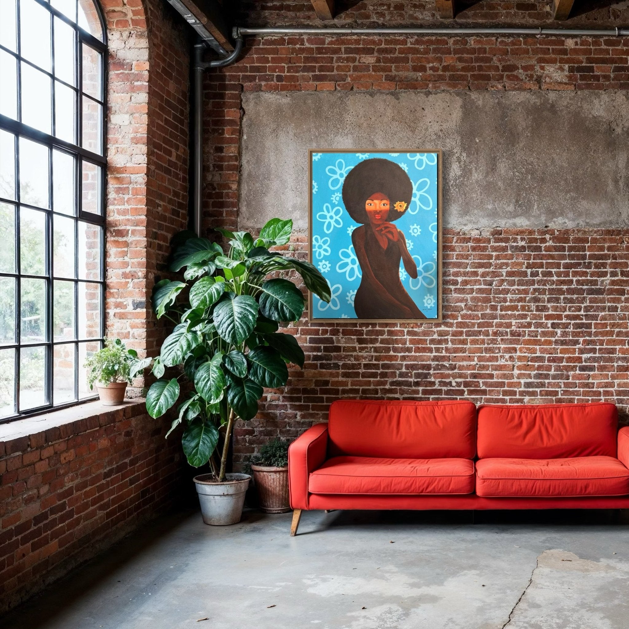 A modern loft with exposed brick, a large window, a bright red sofa, a tall potted plant, and "My Afro 2"—a colorful hand-signed acrylic on canvas by Afuope Opeyemi—displayed above the sofa.