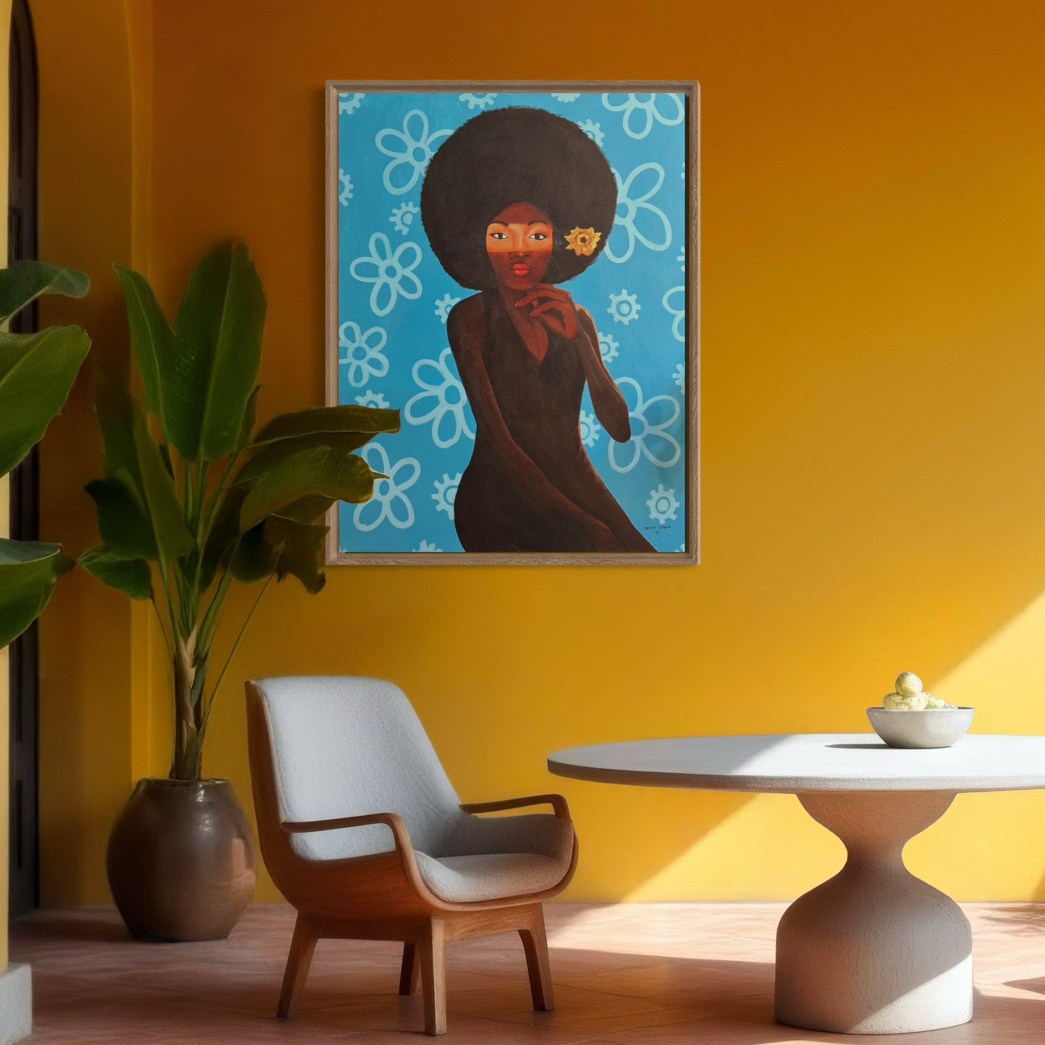 A modern room with yellow walls, a potted plant, gray chair, and round table features "My Afro 2," a hand-signed acrylic on canvas painting by Afuope Opeyemi of a woman with an afro and blue floral background on the wall.