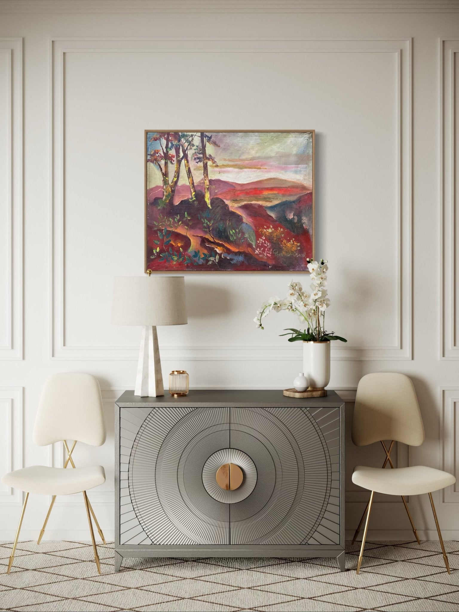 A modern living space with a gray sideboard, two cream chairs, a table lamp, a potted orchid, and "Nature II" Original Landscape Oil Painting by Pitar Alakhume—complete with certificate of authenticity—on the white paneled wall.