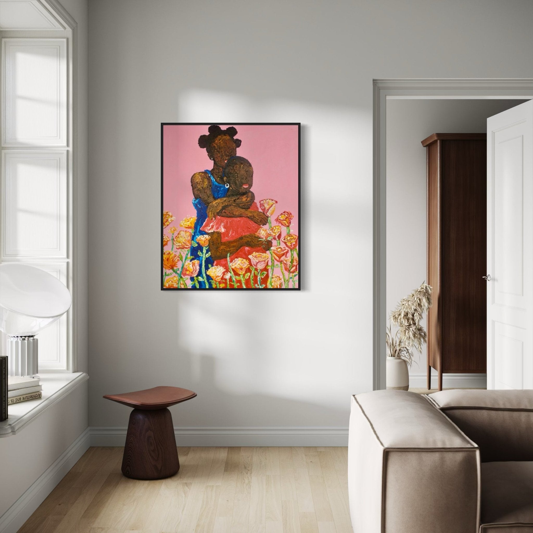A cozy, modern living room with light walls, wood flooring, a beige sofa, a small wooden stool, and Ola Kuti’s "Companion. Acrylic on Canvas" painting of a woman among flowers hanging on the wall. Sunlight streams in from a window.