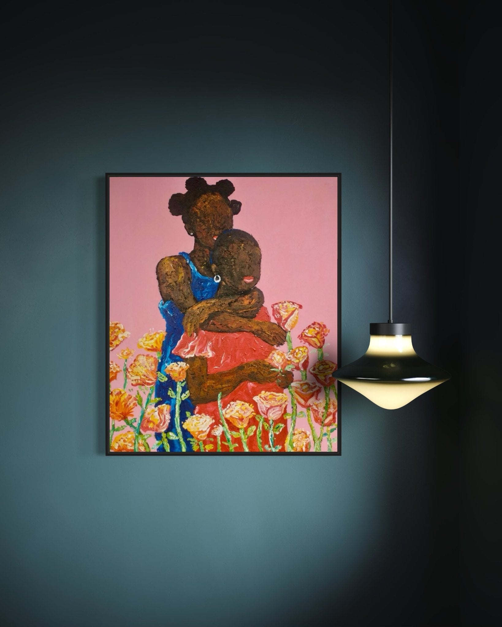 “Companion” by Ola Kuti is an acrylic-on-canvas painting depicting a dark-skinned woman holding a child, set against a pink floral background. The artwork is displayed on a dark wall next to a modern hanging lamp.