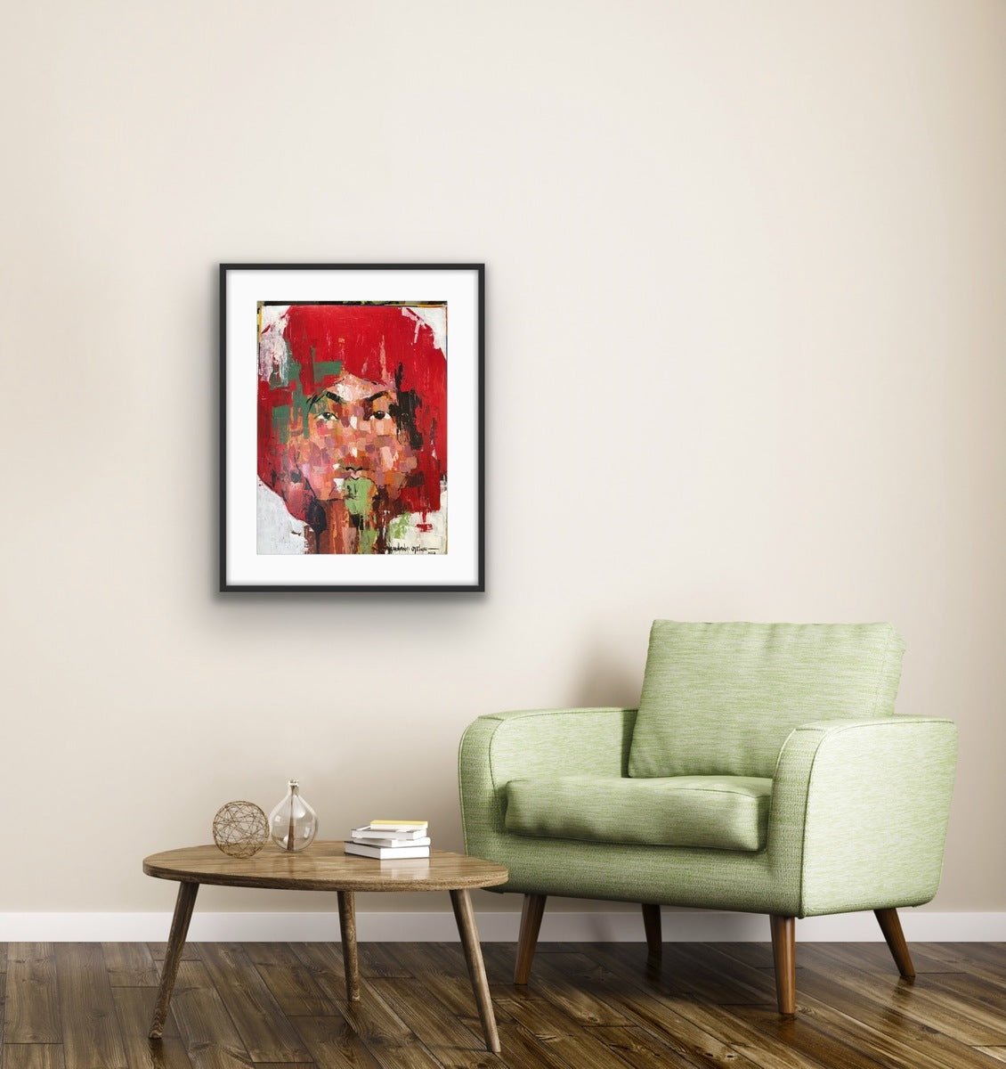 A light green armchair sits next to a round wooden coffee table with books and a vase, against a beige wall adorned with "One of a Kind Series by Oyelusi" from Olasunkanmi Oyelusi, framed in black and hanging above.