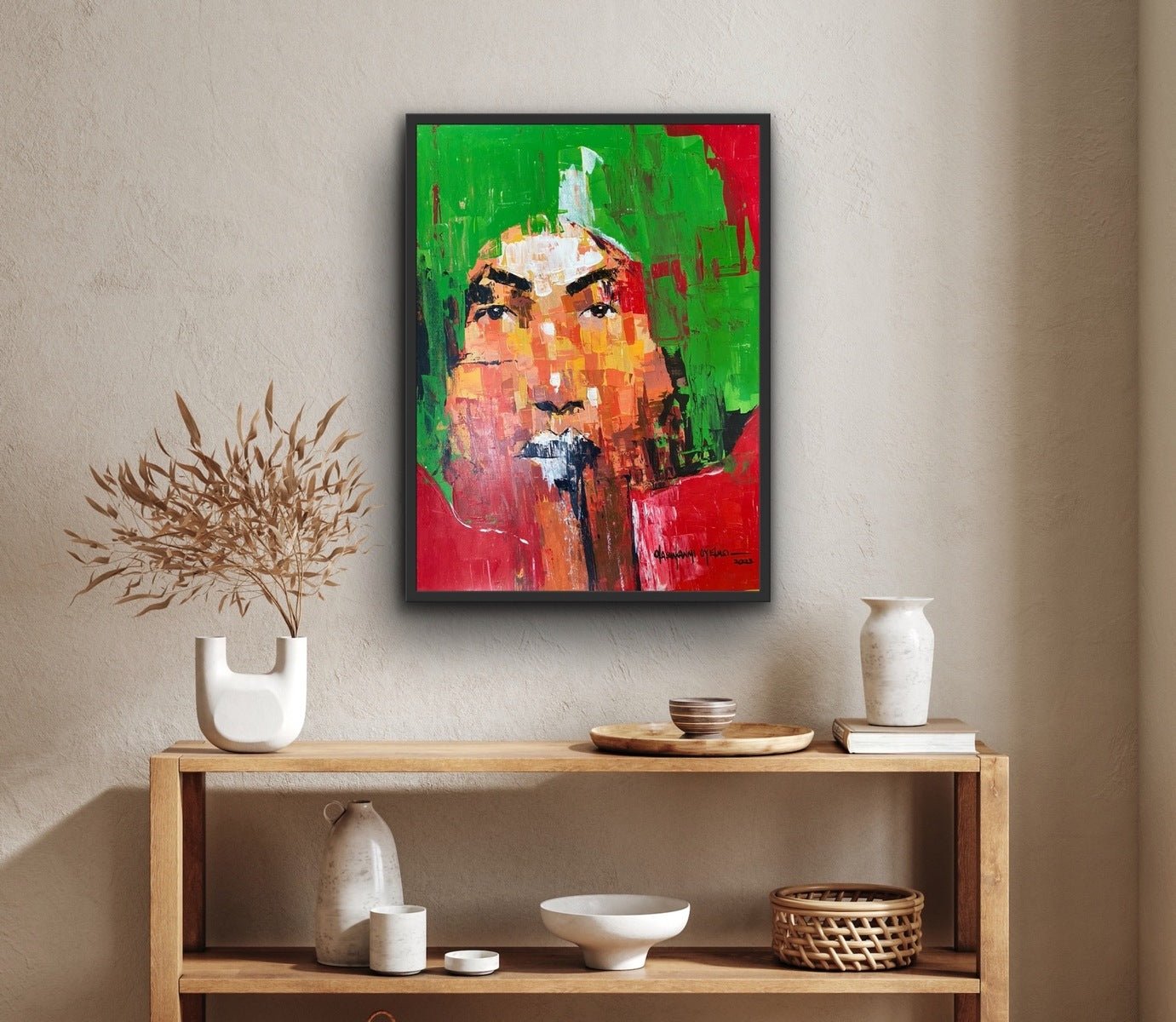 A vibrant acrylic face painting from the "One of a Kind Series by Oyelusi" (Olasunkanmi Oyelusi) adds color above a wooden shelf with minimalist ceramics and dried foliage in a cozy, modern room. Ready to be framed.