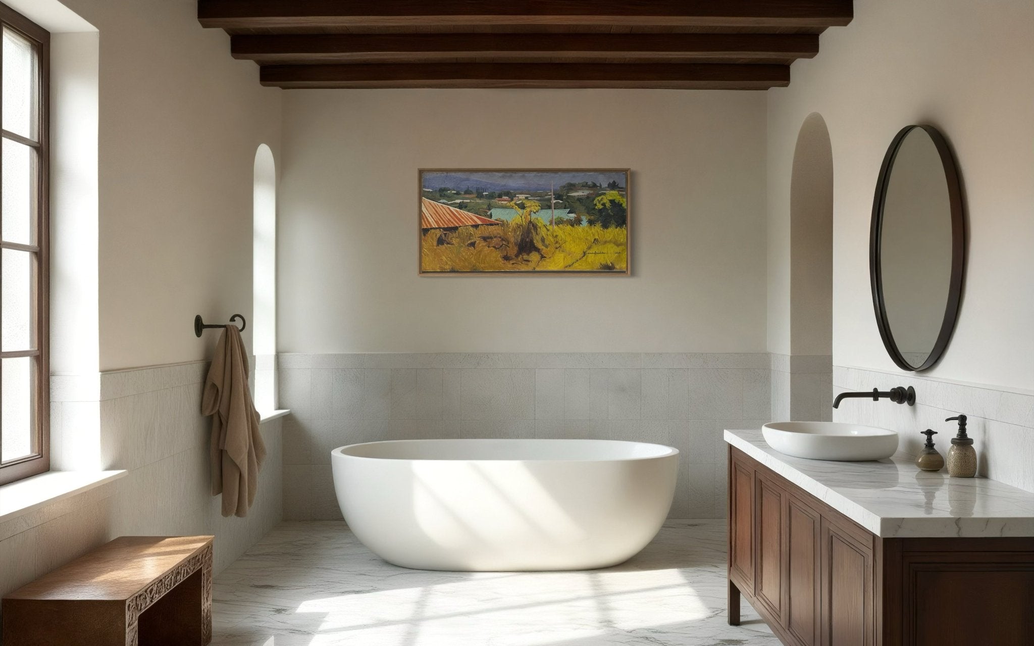A modern bathroom with a freestanding white tub, round mirror above a wooden vanity with vessel sink, towel on a rod, natural light from the window, and "Ouchi Landscape" Oil On Canvas by NOSA OSADOLOR on the wall.