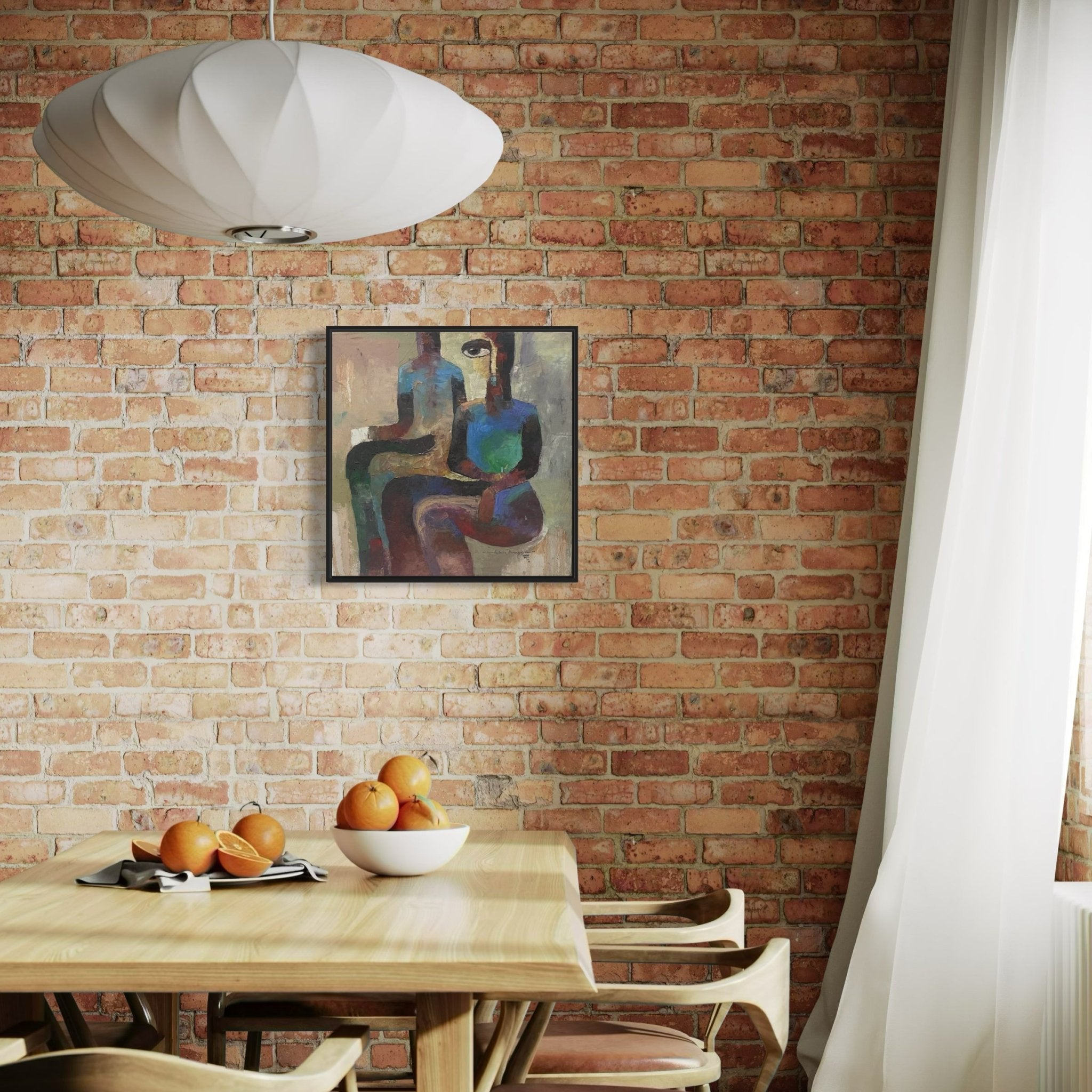 A dining area features a wooden table and chairs, a bowl of oranges, and a modern pendant lamp. Above sheer curtains on the brick wall hangs "Pension Cue," a framed oil artwork by Achike Anayo, hand-signed by the artist.
