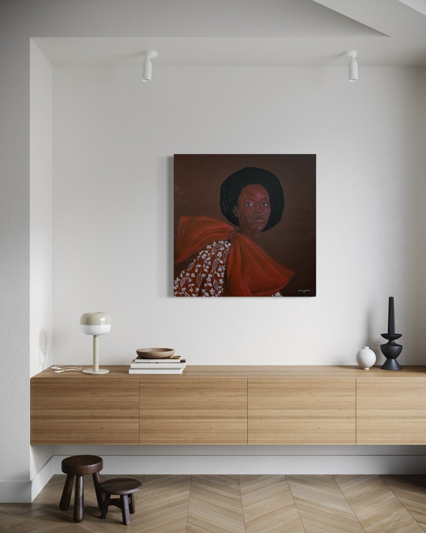 A modern minimalist living room with light walls, a wooden sideboard, stools, and decor. Above the sideboard hangs "Portrait by Hammed Omobayo" from Hammed Olayanju Omobayo—a hand-signed painting with a certificate of authenticity.