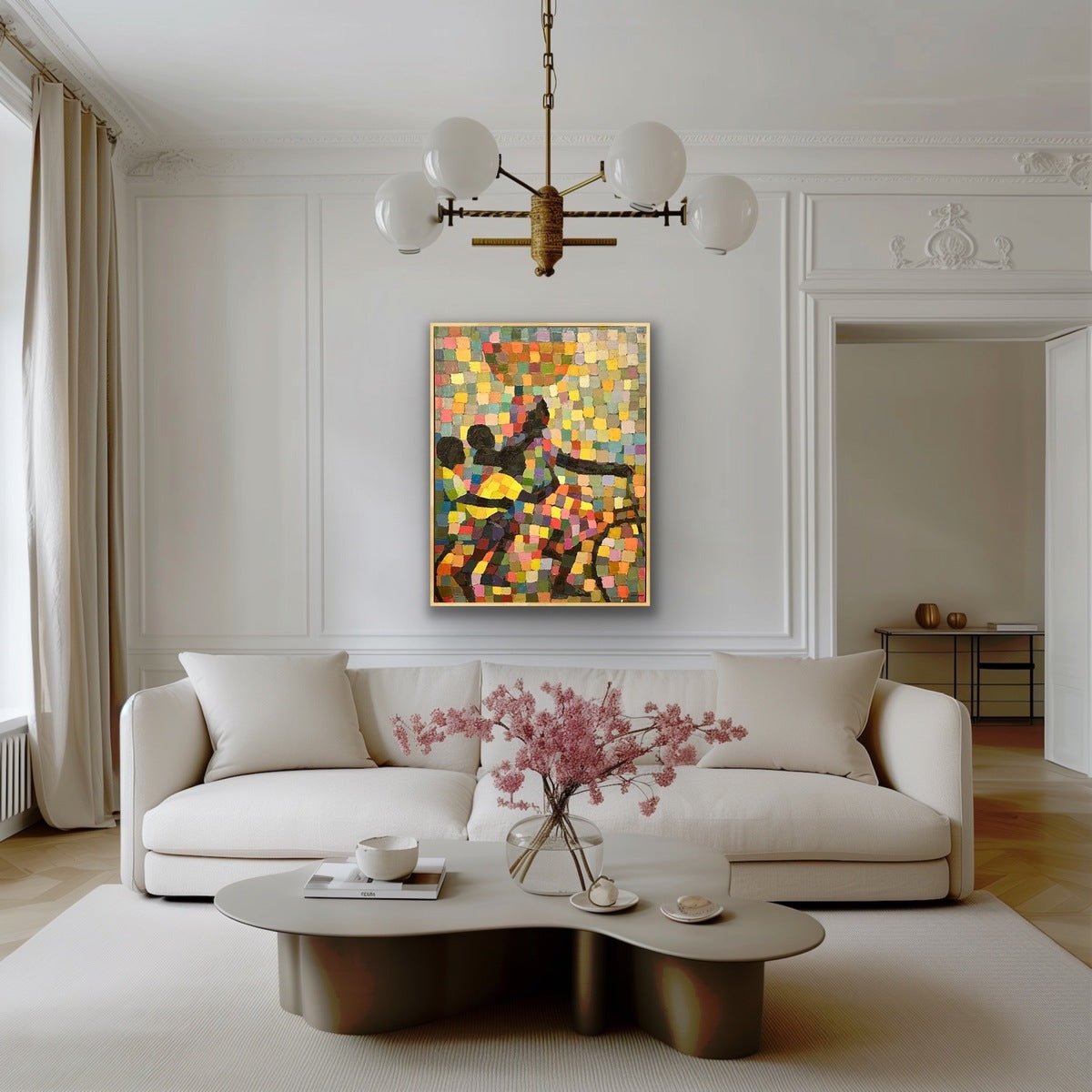 A stylish living room features a white sofa, modern coffee table, and “Power in mother” by Lola—a colorful abstract acrylic on canvas, hand-signed with a certificate of authenticity—displayed above the sofa. An elegant chandelier and natural light complete the look.