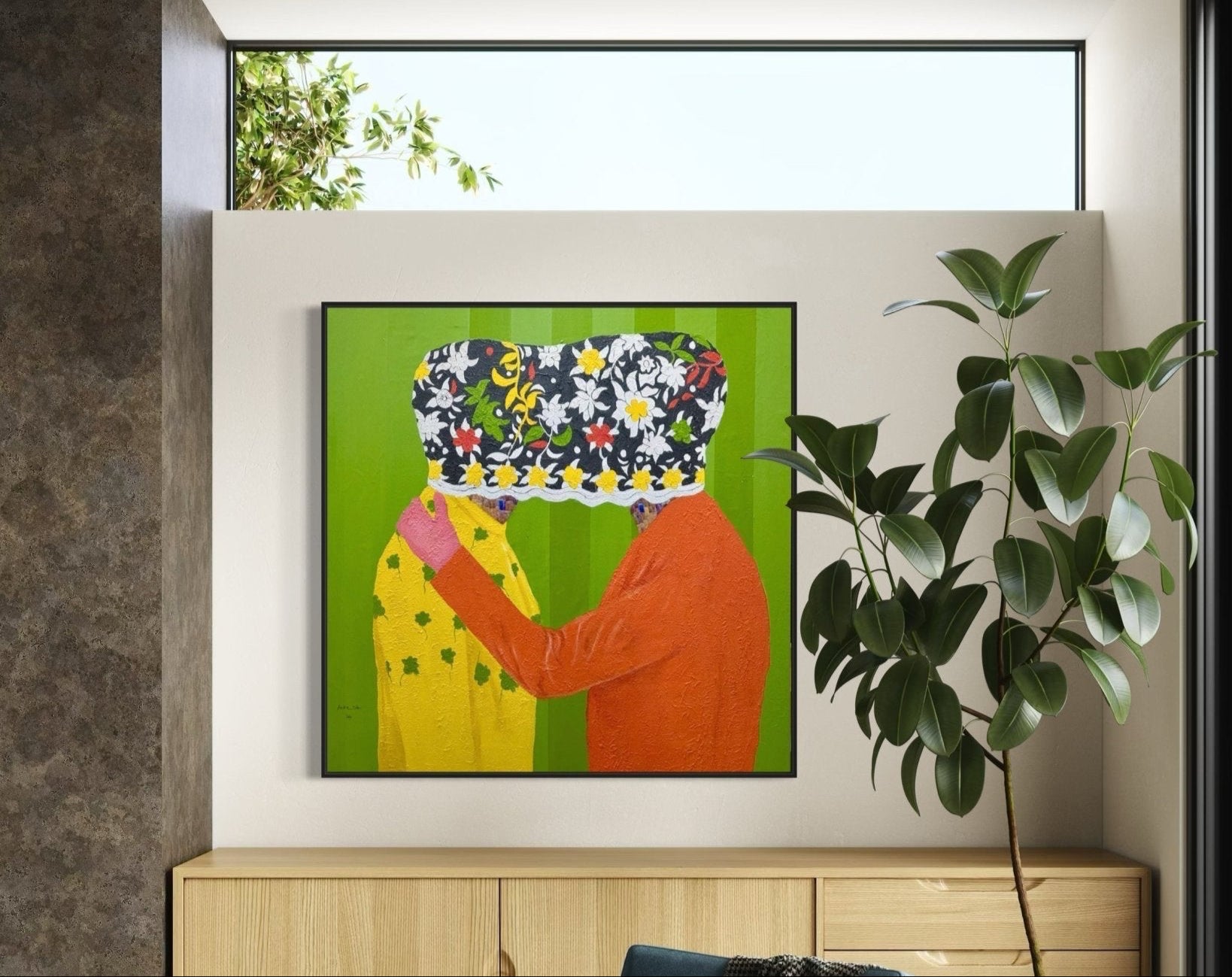 A modern interior features a leafy plant next to a wooden cabinet. On the wall hangs "Secrets" 122 x 122cm by Slam Austin, an acrylic painting of two embracing figures with faces hidden by a patterned object on bright green.