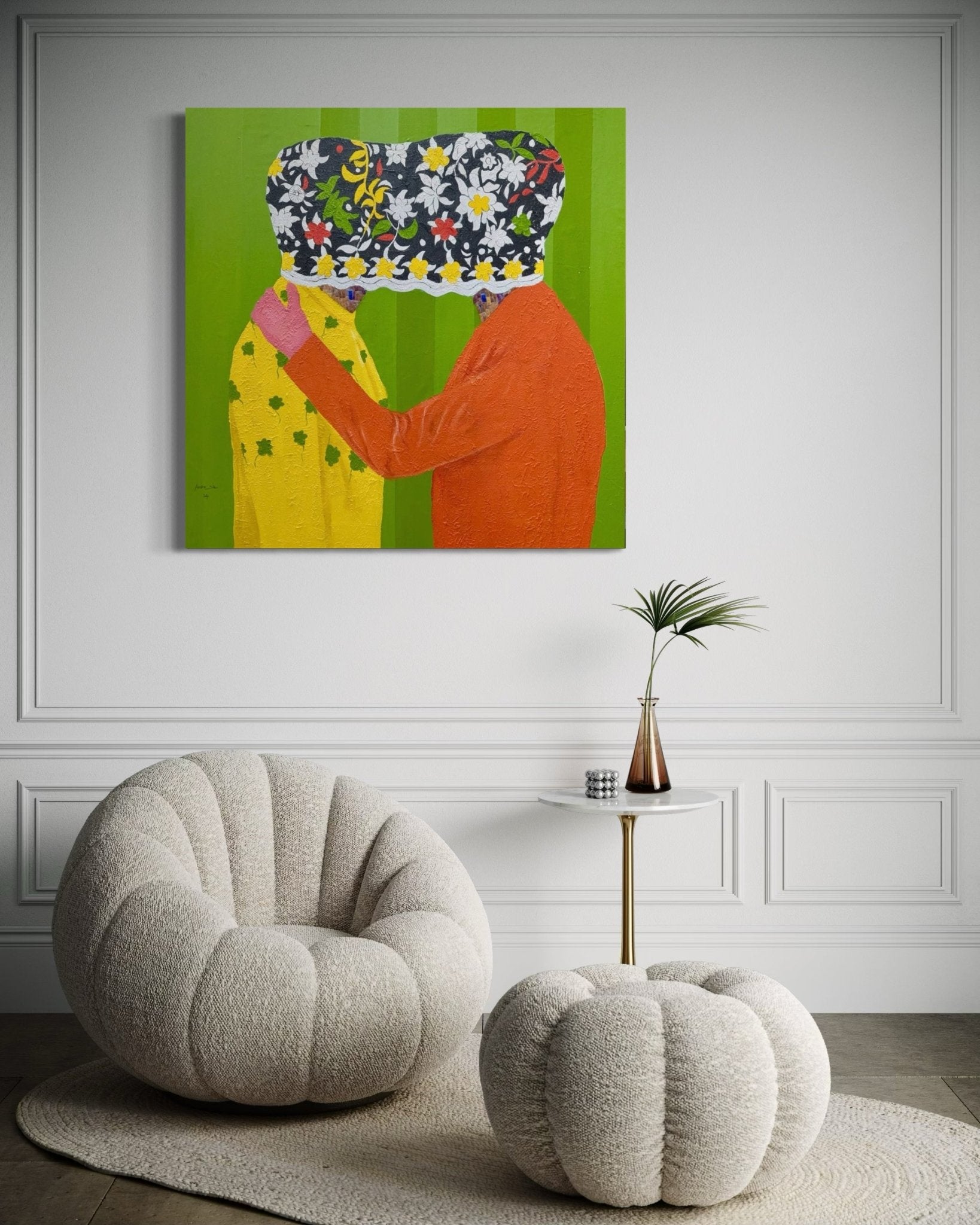 A modern living room with two plush beige chairs, a small round table with a vase, and "Secrets" 122 x 122cm by Slam Austin—an acrylic painting depicting two figures with their faces covered by patterned cloth.