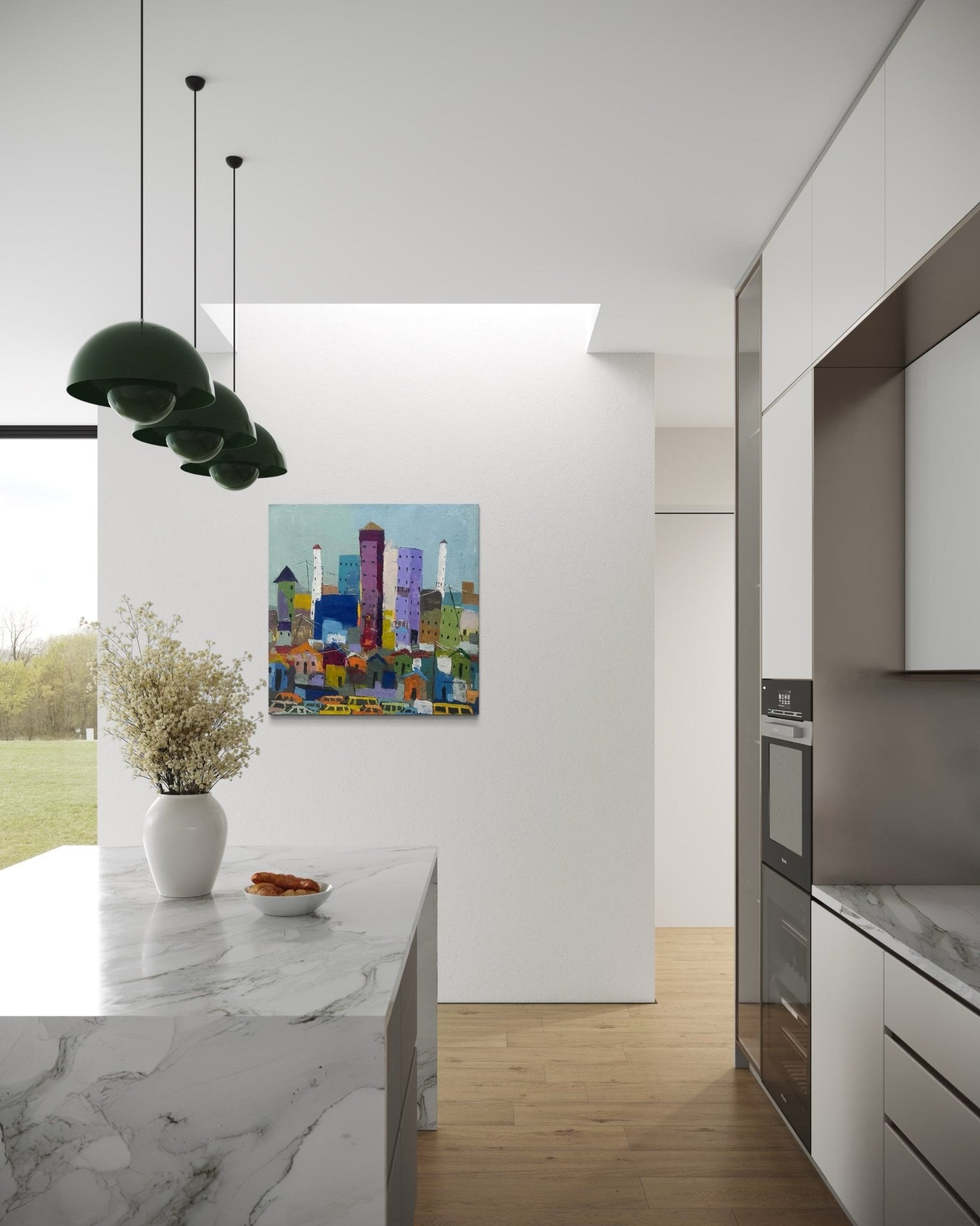 A modern kitchen with white cabinets, marble counters, green pendant lights, and a vase of flowers. 'Somewhere In Lagos City' artwork by Achike Anayo with certificate of authenticity hangs on the wall near a large window to grassy views.