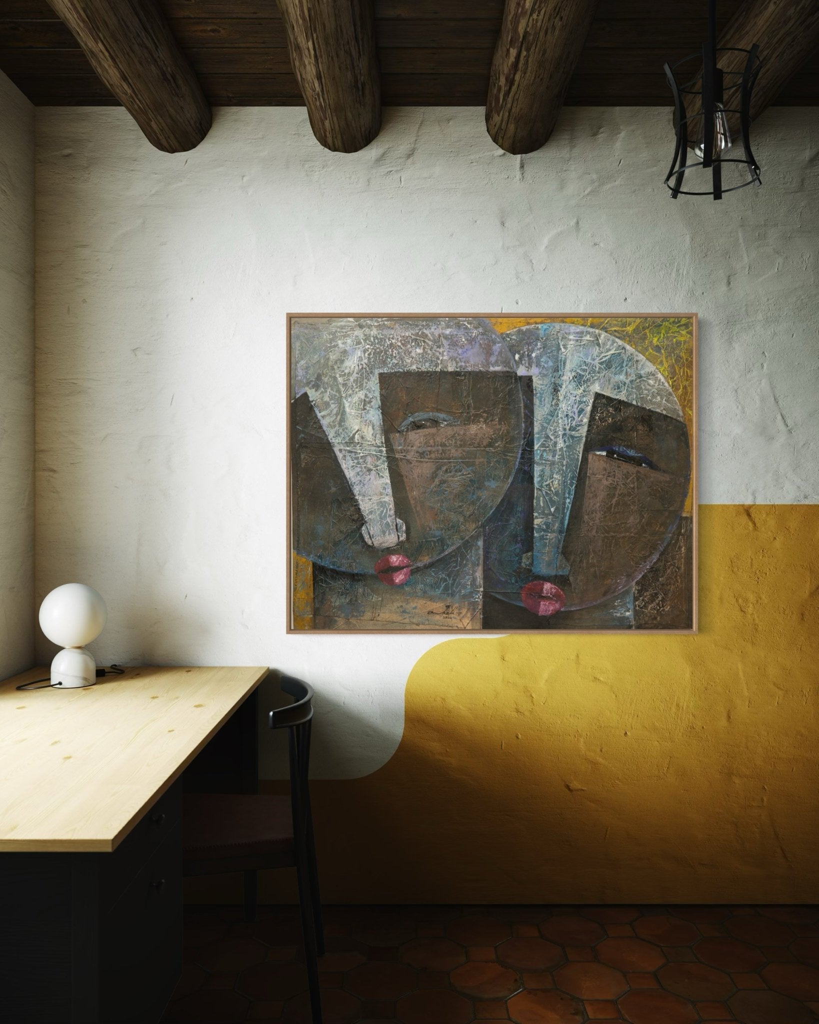 A modern desk with a black chair and white lamp sits against a white and yellow wall, topped by "Sour Ties," an abstract faces collage painting by Nigerian artist Christopher Ankeli.