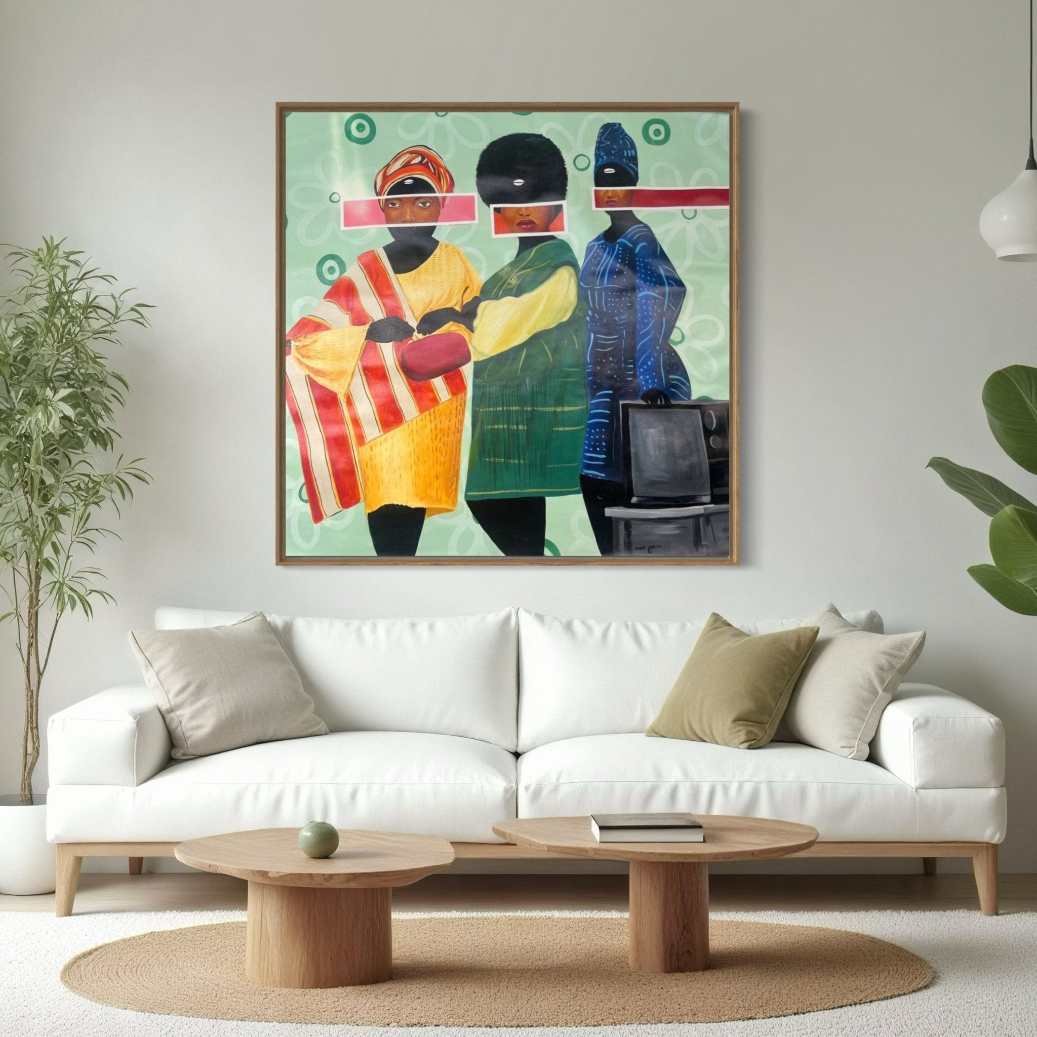 A modern living room with a white sofa, round wooden coffee tables, a green plant, and "Sunday Best" by Afuope Opeyemi—a large, hand-signed acrylic on canvas of three abstract figures with certificate of authenticity—displayed above the sofa.