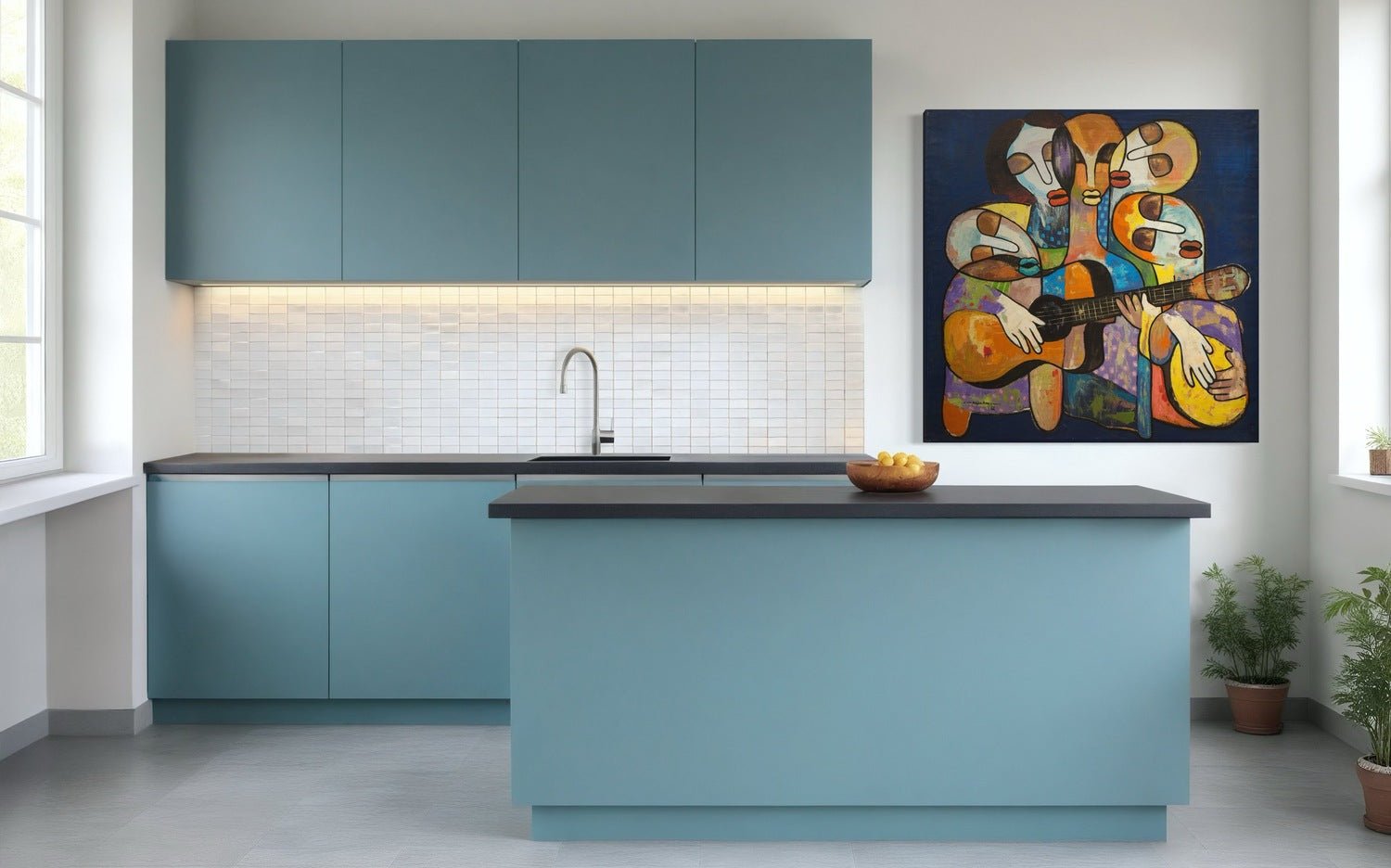 A modern kitchen with matte blue cabinets, black island, bowl of apples, and "Sweet Tunes"—a hand-signed acrylic abstract painting of musicians by Achike Anayo—on the wall. White tile backsplash and potted plants complete the bright space.