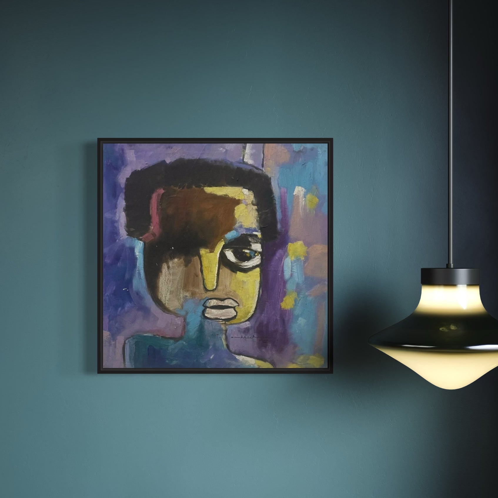 ‘The Face’ by Achike Anayo, a colorful abstract portrait with bold brushstrokes and vivid hues, hangs on a teal wall beside a modern black and white pendant lamp.