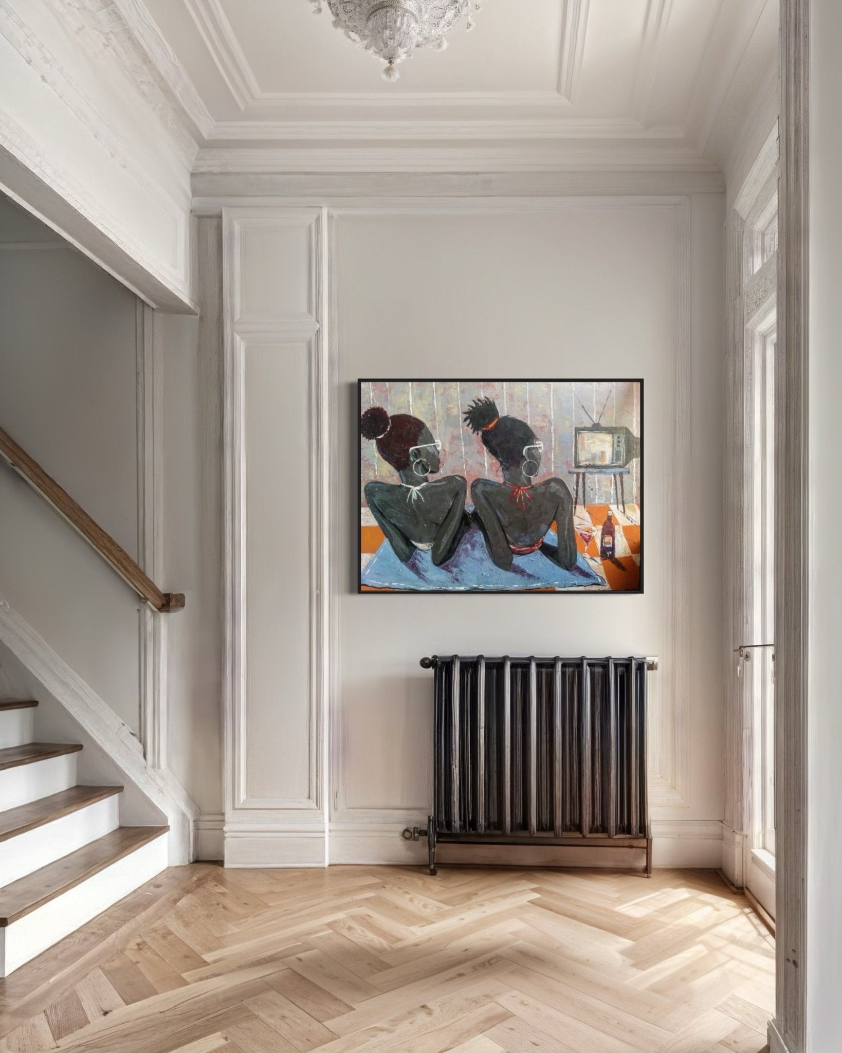 A bright hallway with herringbone wood floors, white paneled walls, and a dark radiator beneath "Tween Vacation," a hand-signed Lucky Isaiah artwork with a certificate of authenticity, creates an inviting space.