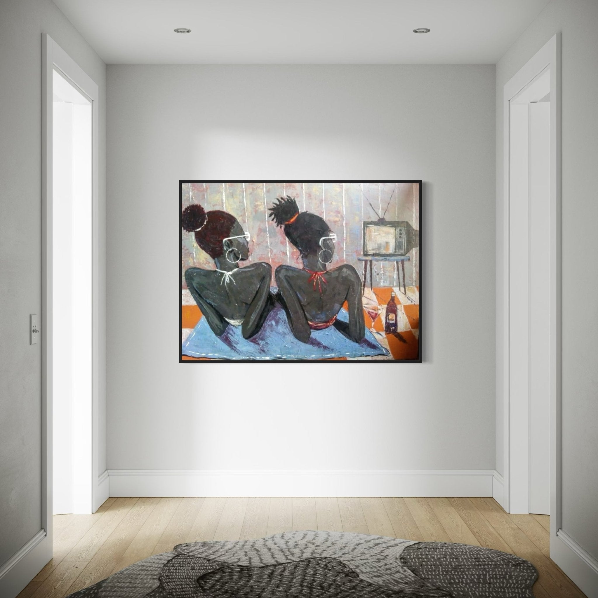 A minimalist hallway with light gray walls, wooden floors, and a circular rug features "Tween Vacation" by Lucky Isaiah—a colorful signed artwork of two back-to-back figures with a TV and bottles.