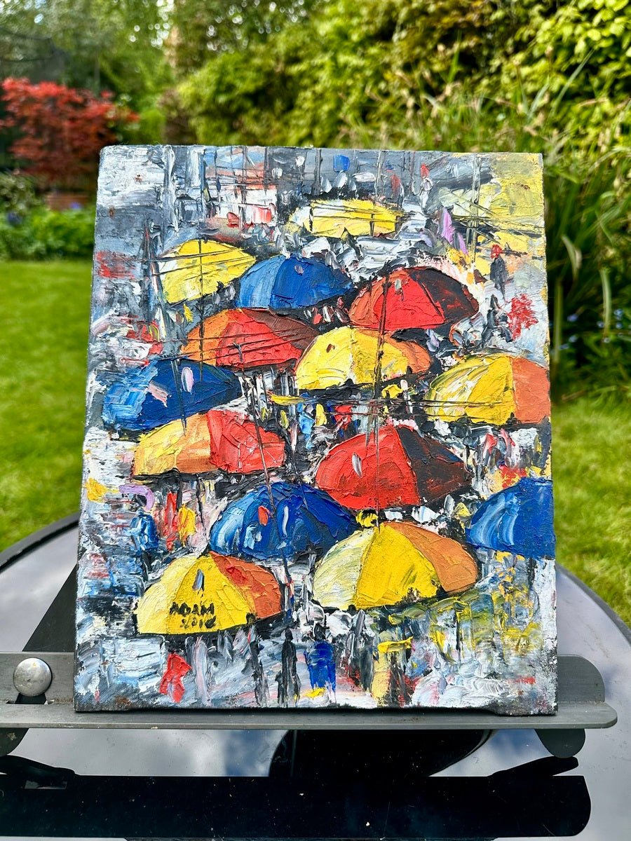 Heavily Textured Miniature Acrylic On Canvas Painting by Adam, "Umbrellas in The Sun. Street Market"—a vibrant scene of people with yellow, red, and blue umbrellas, reminiscent of lively Nigerian street markets. Brand: Adam.