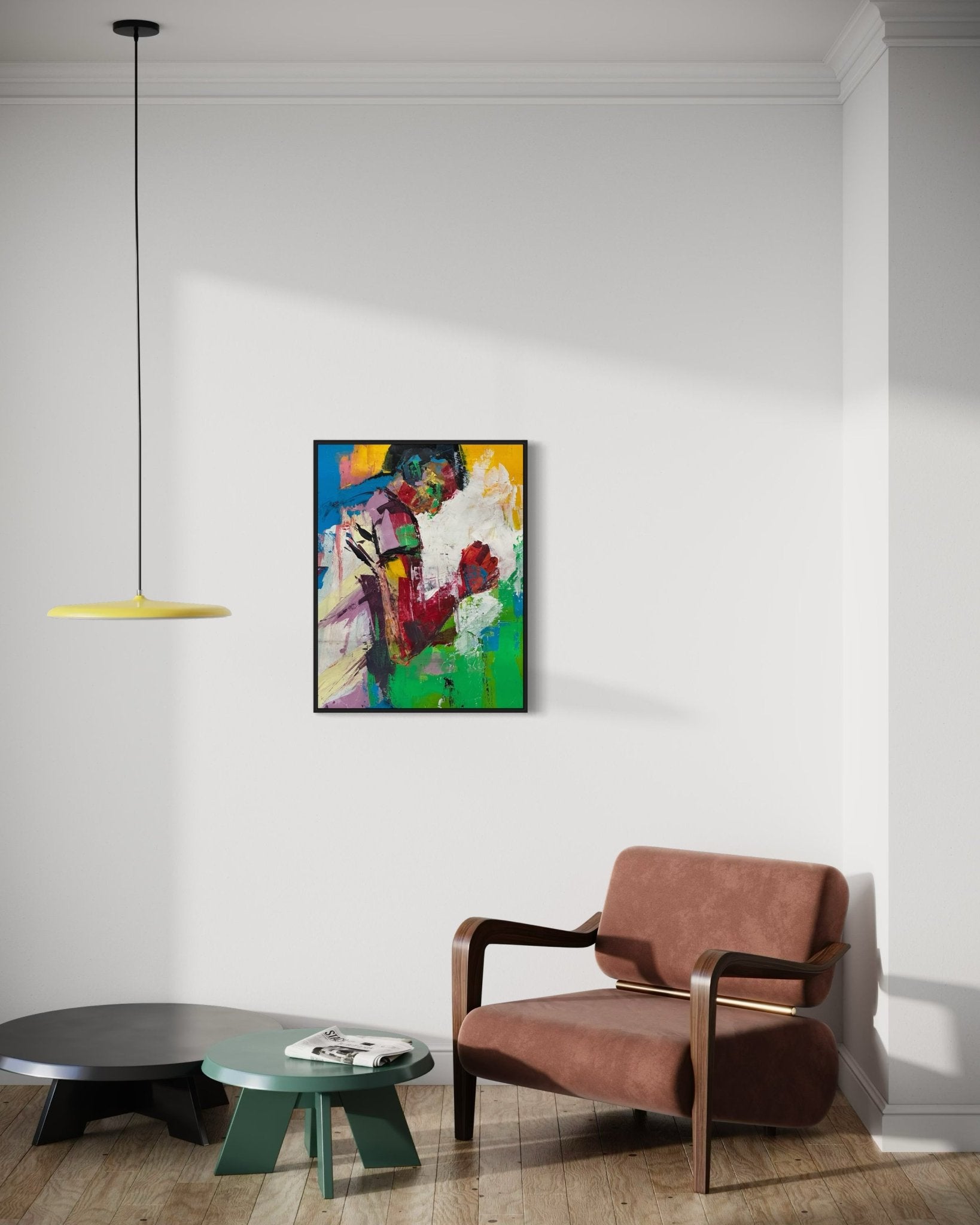 A modern living room features a brown armchair, two low tables, and 'That Happy Feeling' Original Painting by Olasunkanmi Oyelusi on the white wall. A yellow pendant light hangs above as sunlight casts soft shadows on the wooden floor.