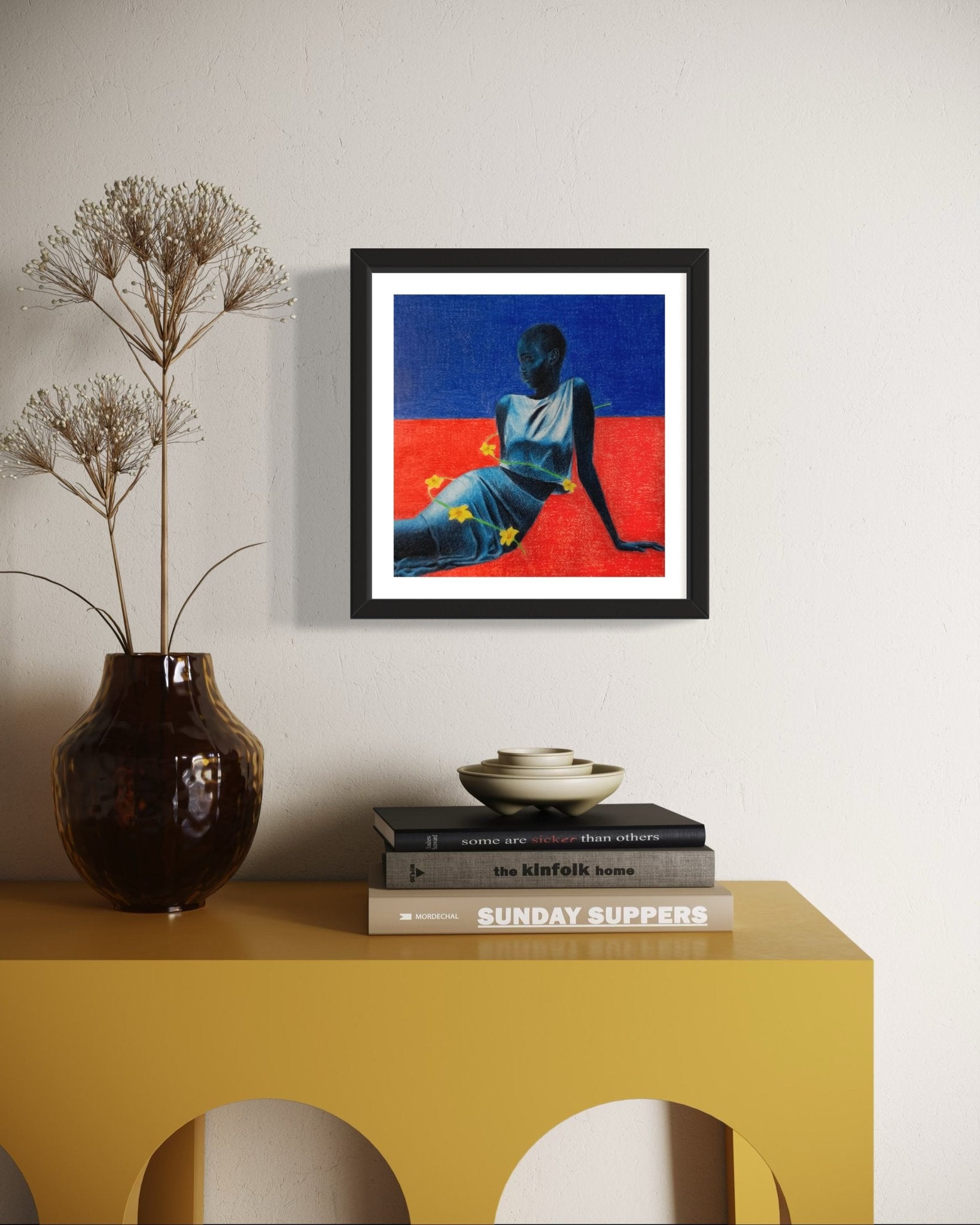 'Blue Maiden II' by Mubarak Omotoyosi, featuring a seated figure on red and blue, arrives framed in sleek black. Hang it above a mustard console with books, vase, and bowl. Includes certificate of authenticity from Mubarak Omotoyosi.