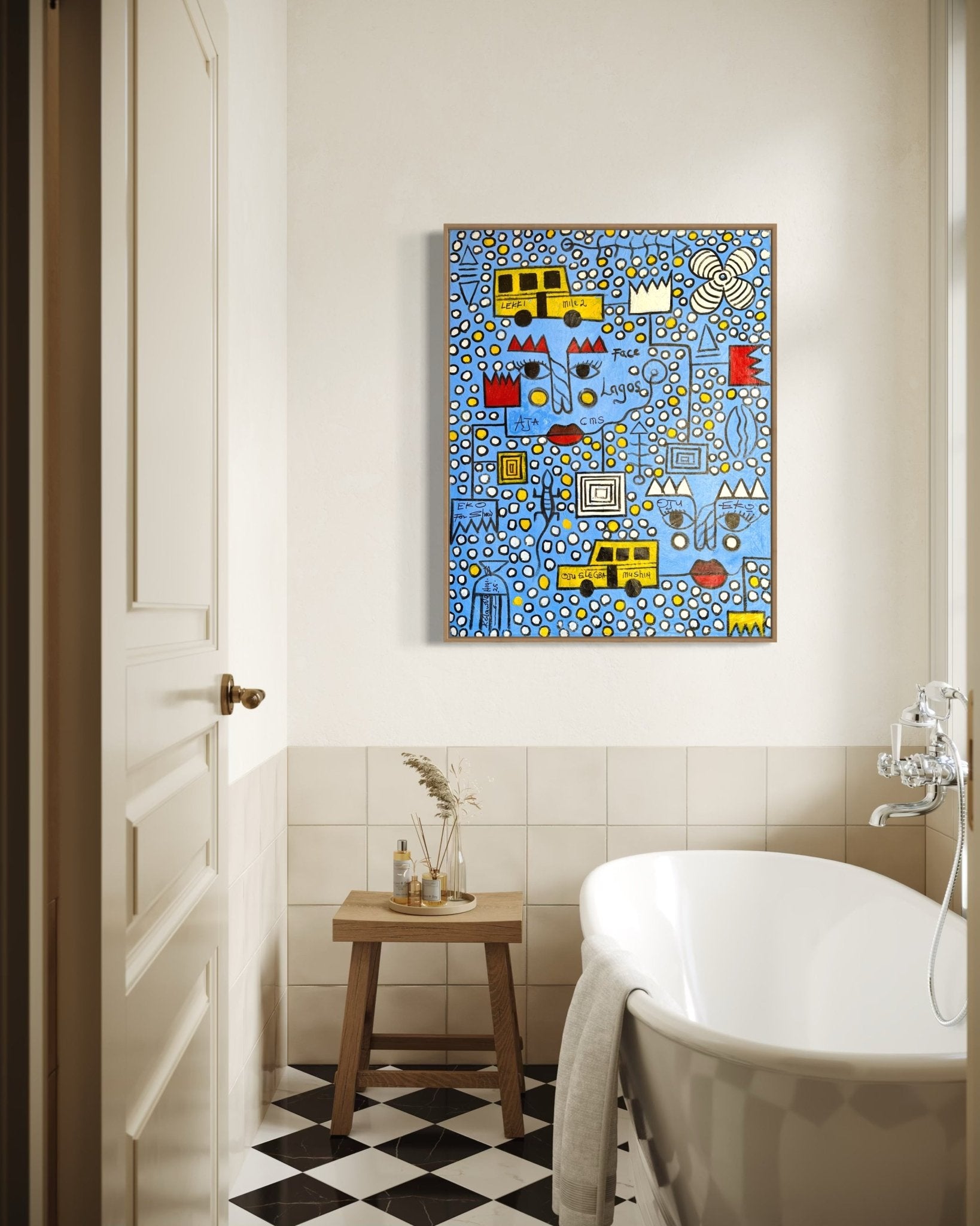 A bright bathroom features a white tub, checkered black-and-white floor, small wooden stool with toiletries, and "Face Of Lagos" by Kolawale Niyi—a colorful abstract painting with blue, yellow, and red geometric shapes.